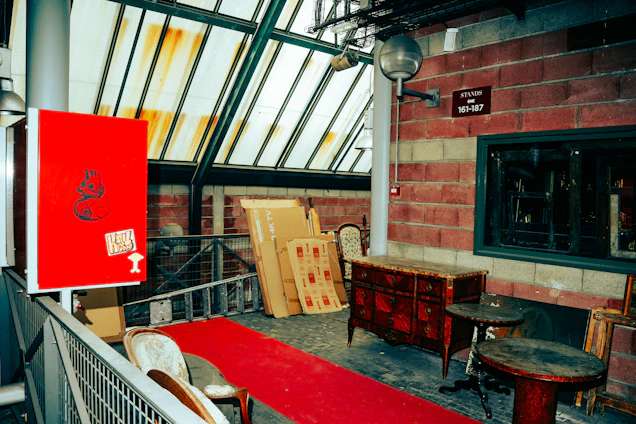 Red carpet leads to antique furniture display.