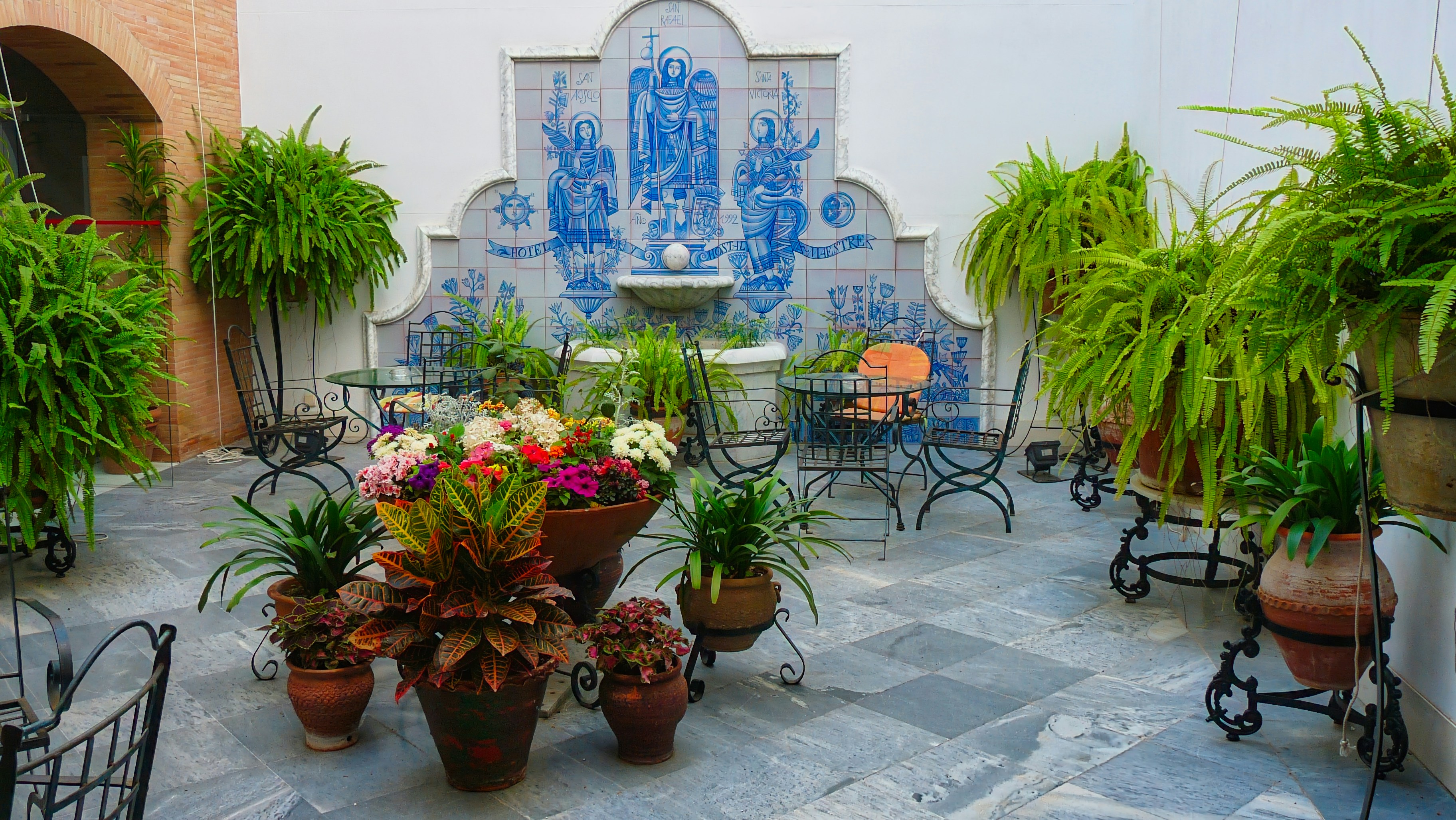 Innenhof mit gefliestem Brunnen und Topfpflanzen