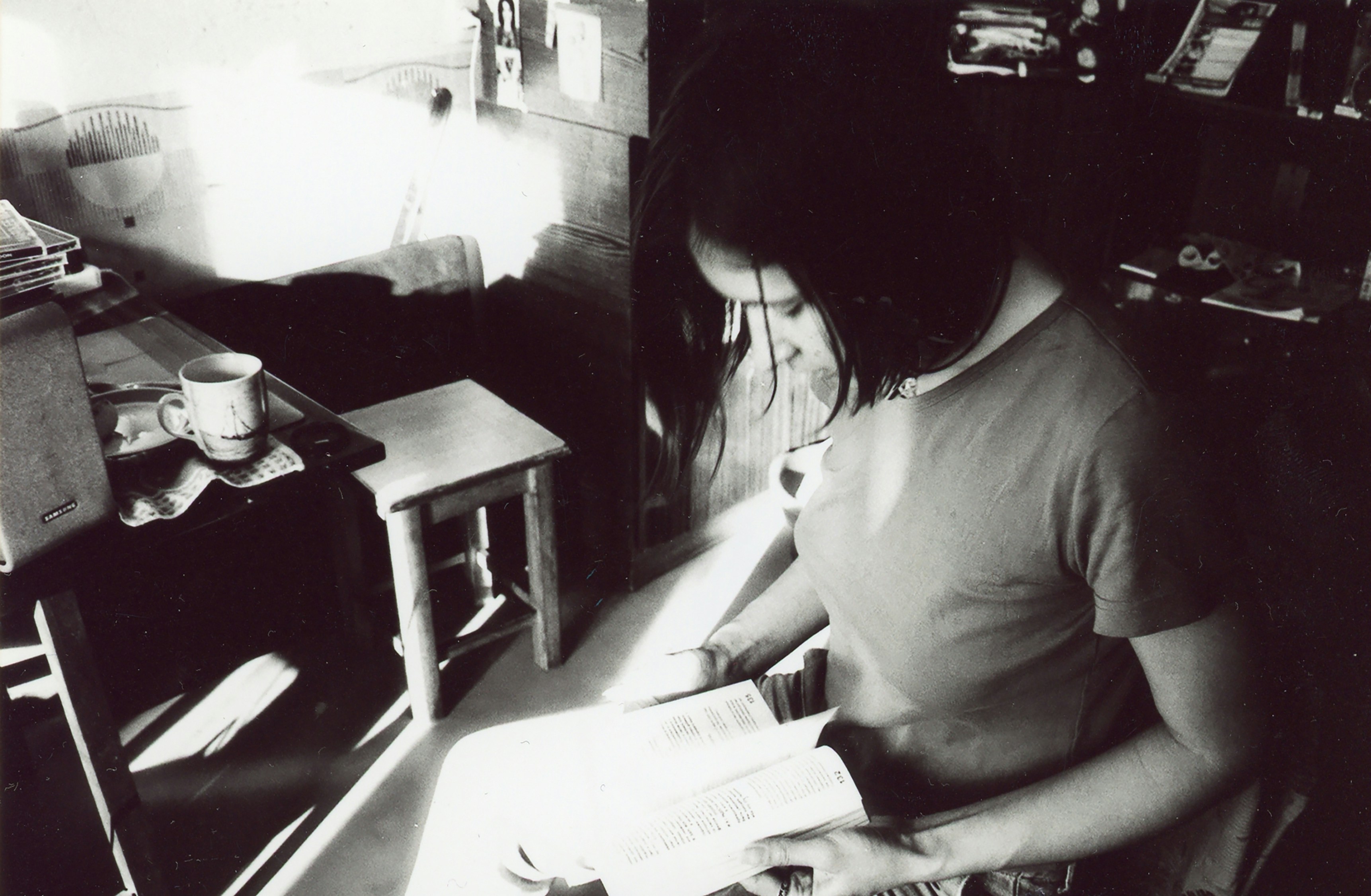A person reading a book by a window.