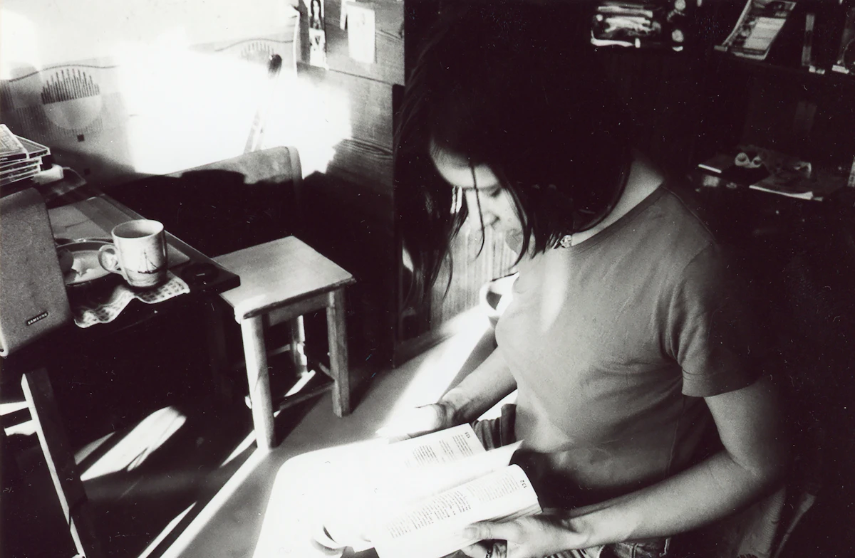 A person quietly reading by a sunlit window