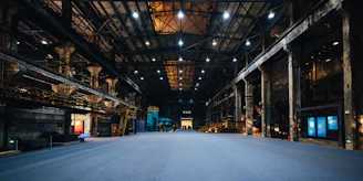 Vast empty industrial warehouse with overhead lighting