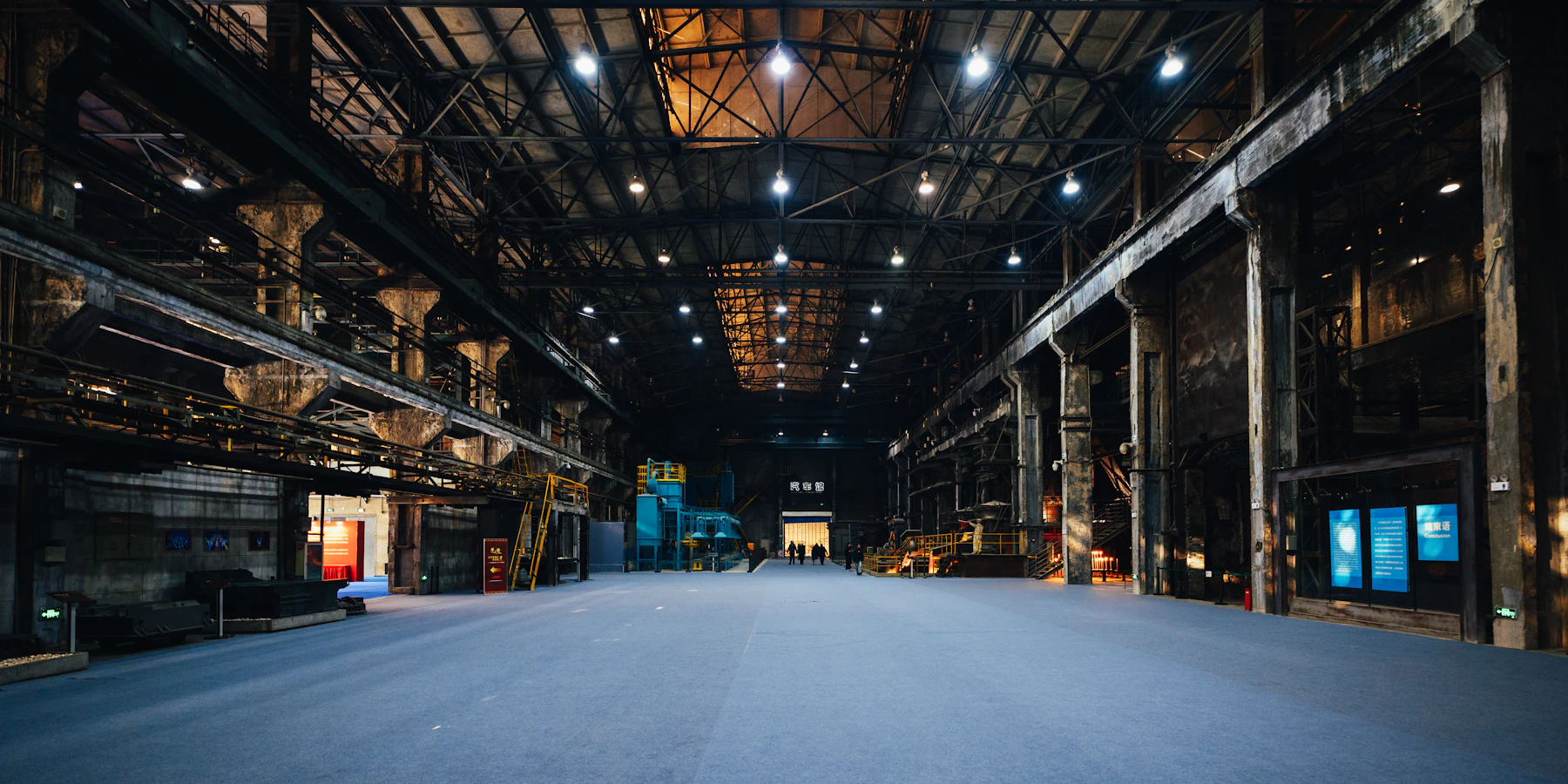Empty industrial exhibition hall with dramatic overhead truss lighting