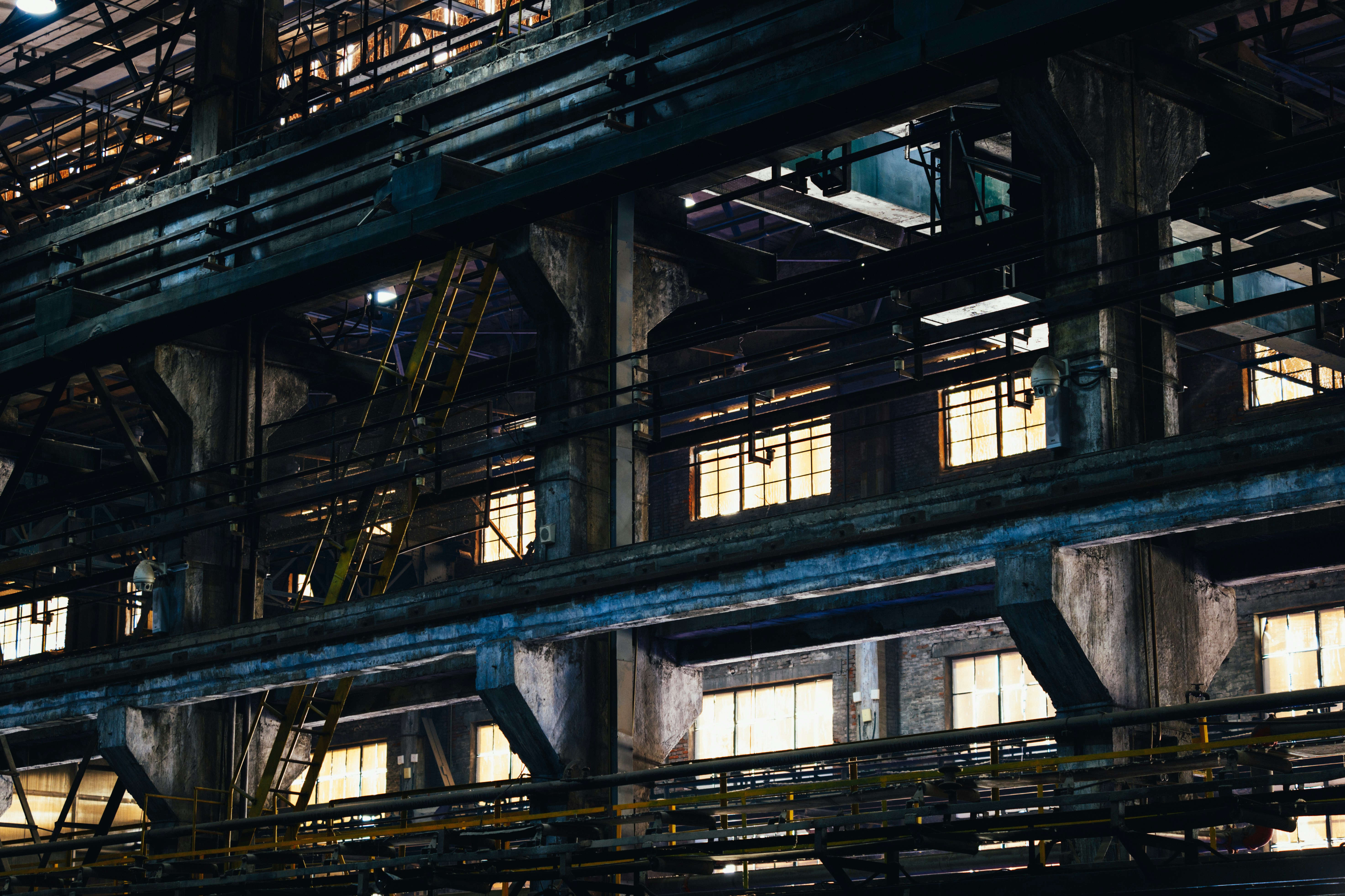 Interior of an old, industrial factory with large windows.