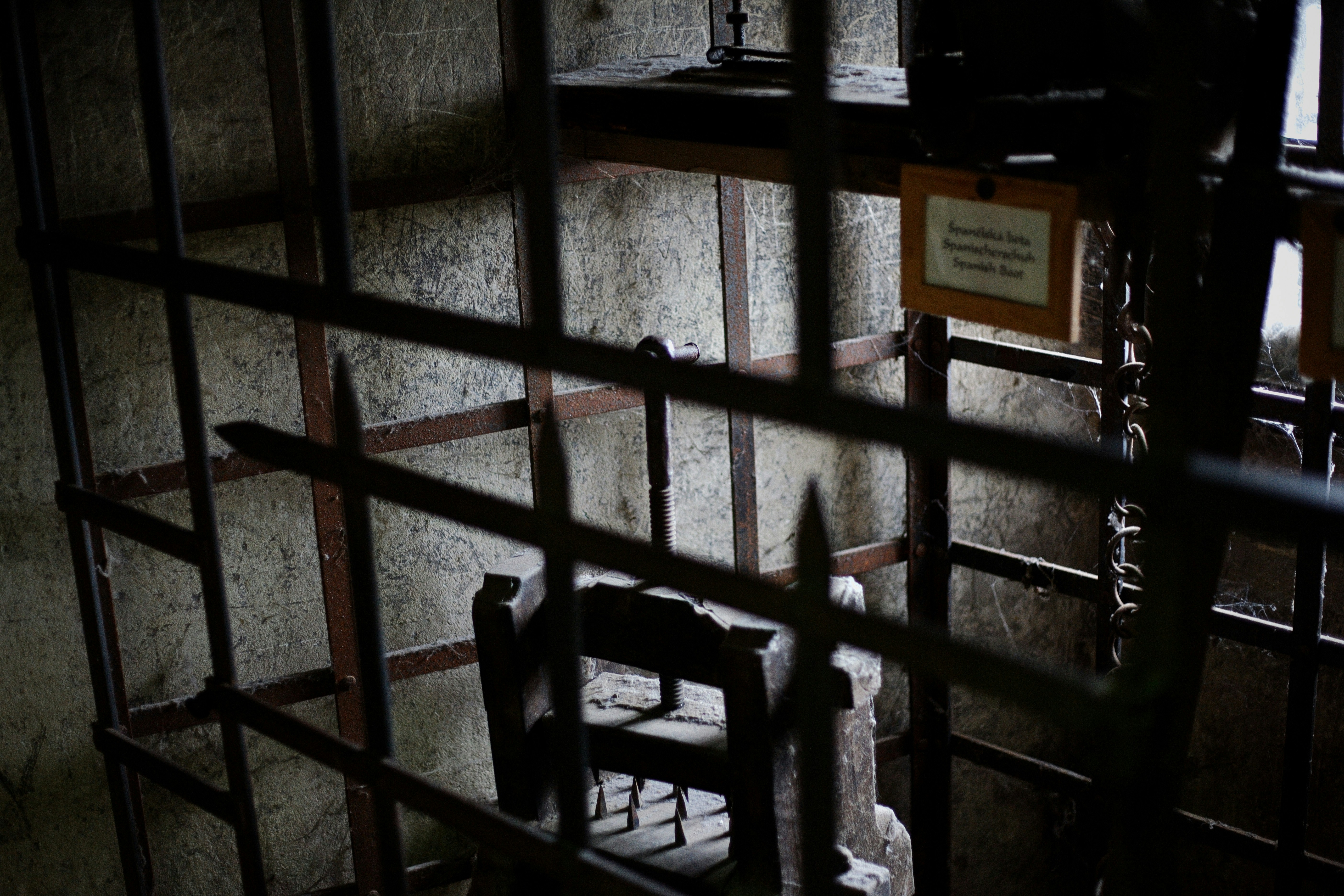 An empty iron cage with a chair inside
