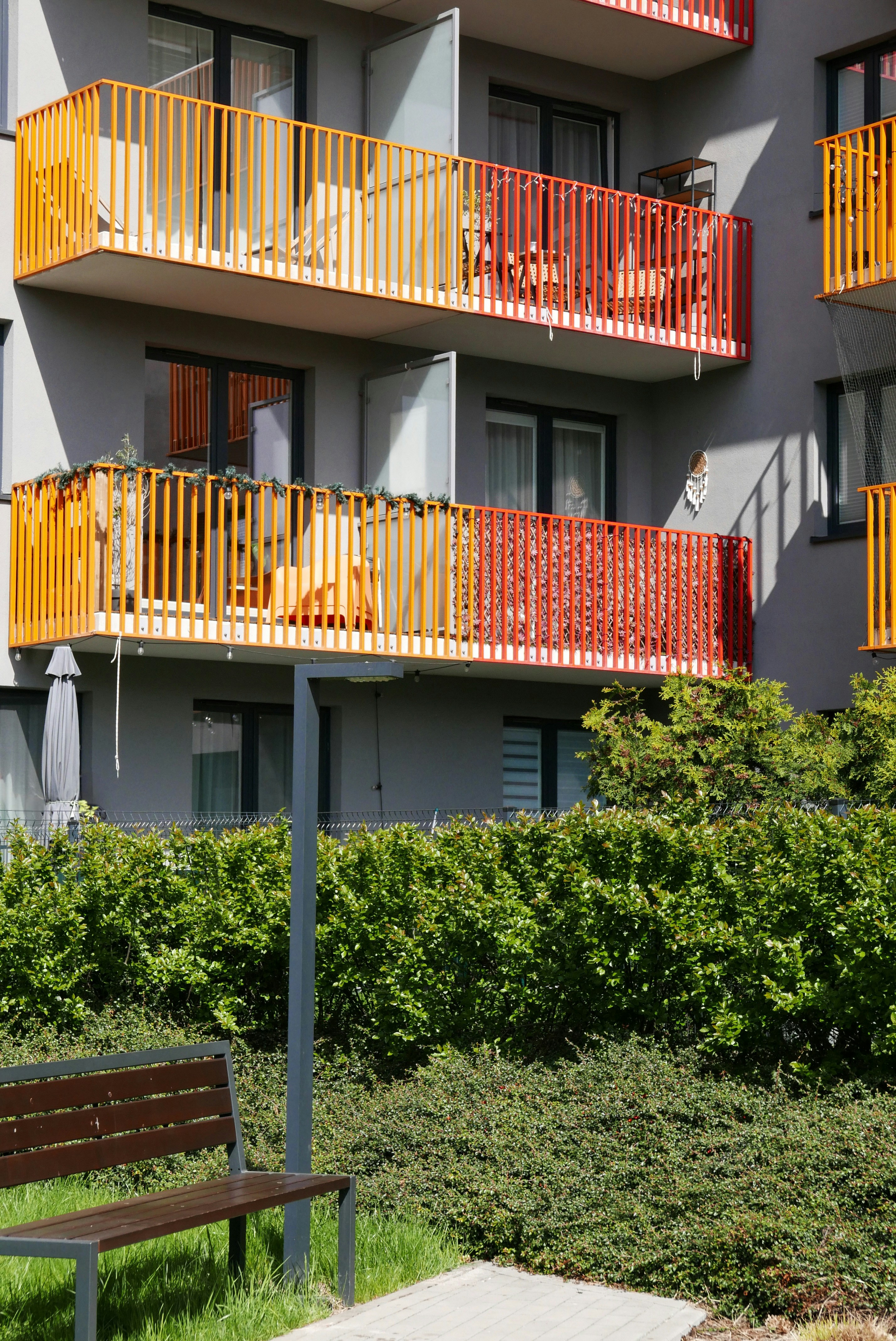 Modern apartment building with colorful balconies and green bushes