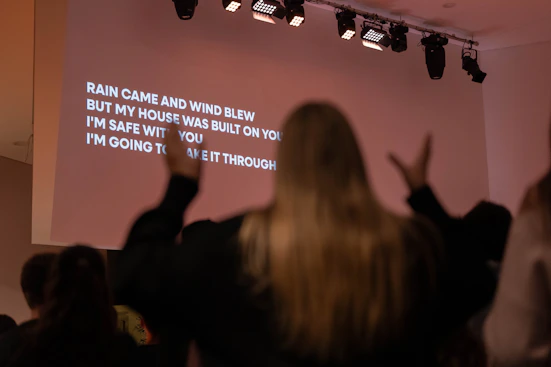 Woman singing along to lyrics projected on screen