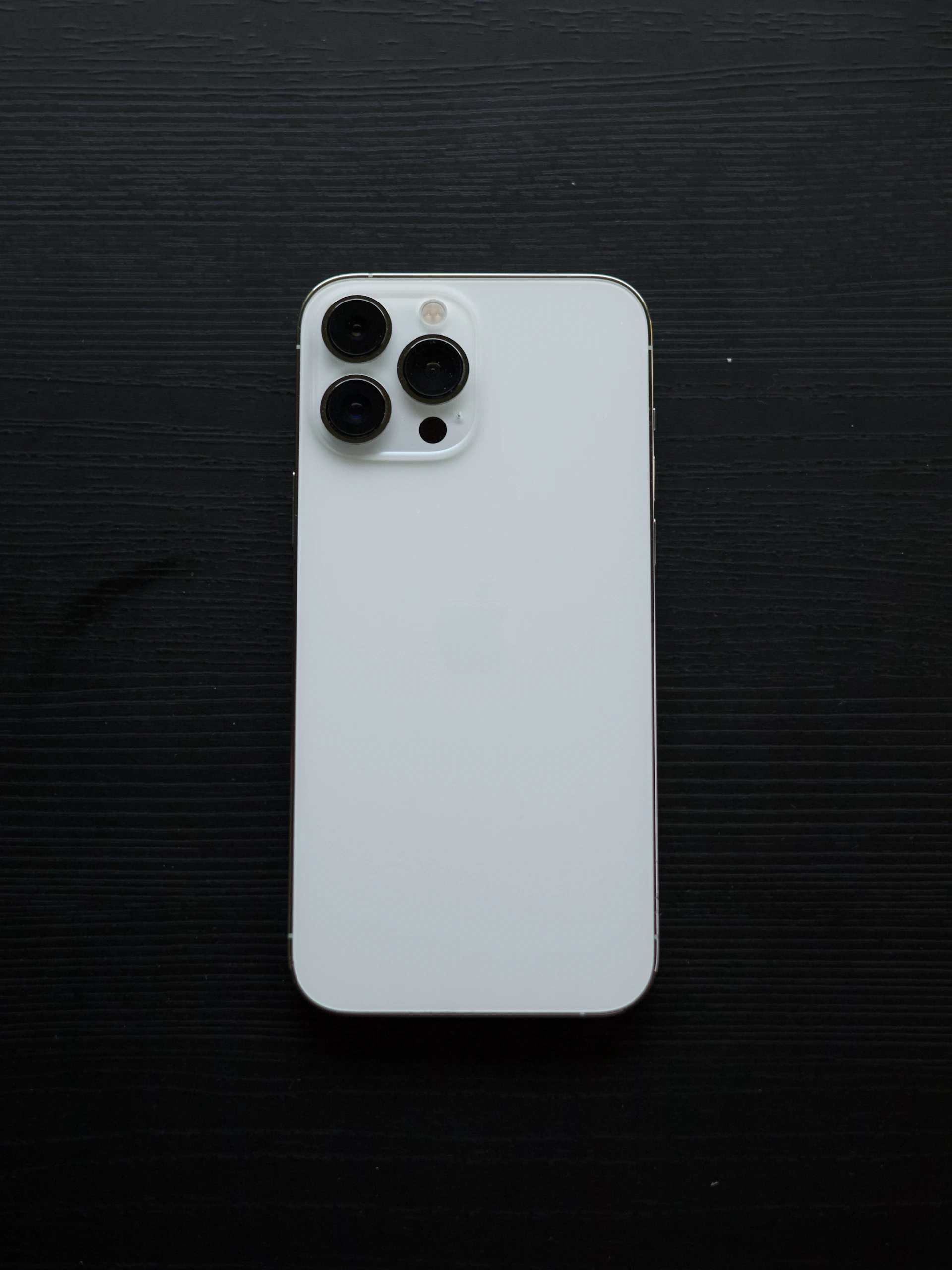 White smartphone with three cameras on black background