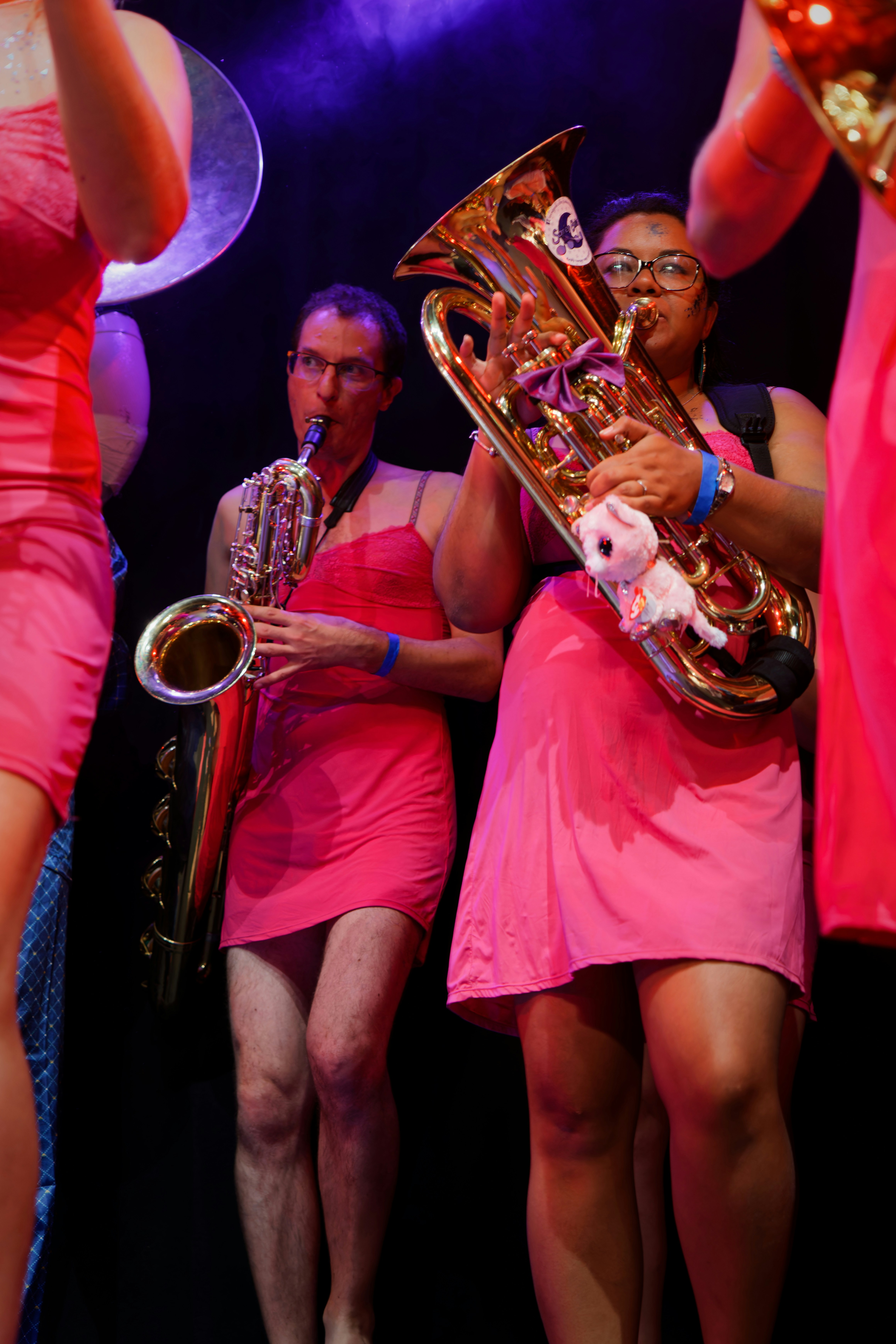 Músicos con vestidos rosas tocan instrumentos de metal
