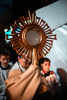 Clergy holds a golden monstrance with host during ceremony