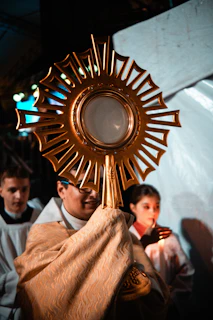 Clergy holds a golden monstrance with host during ceremony