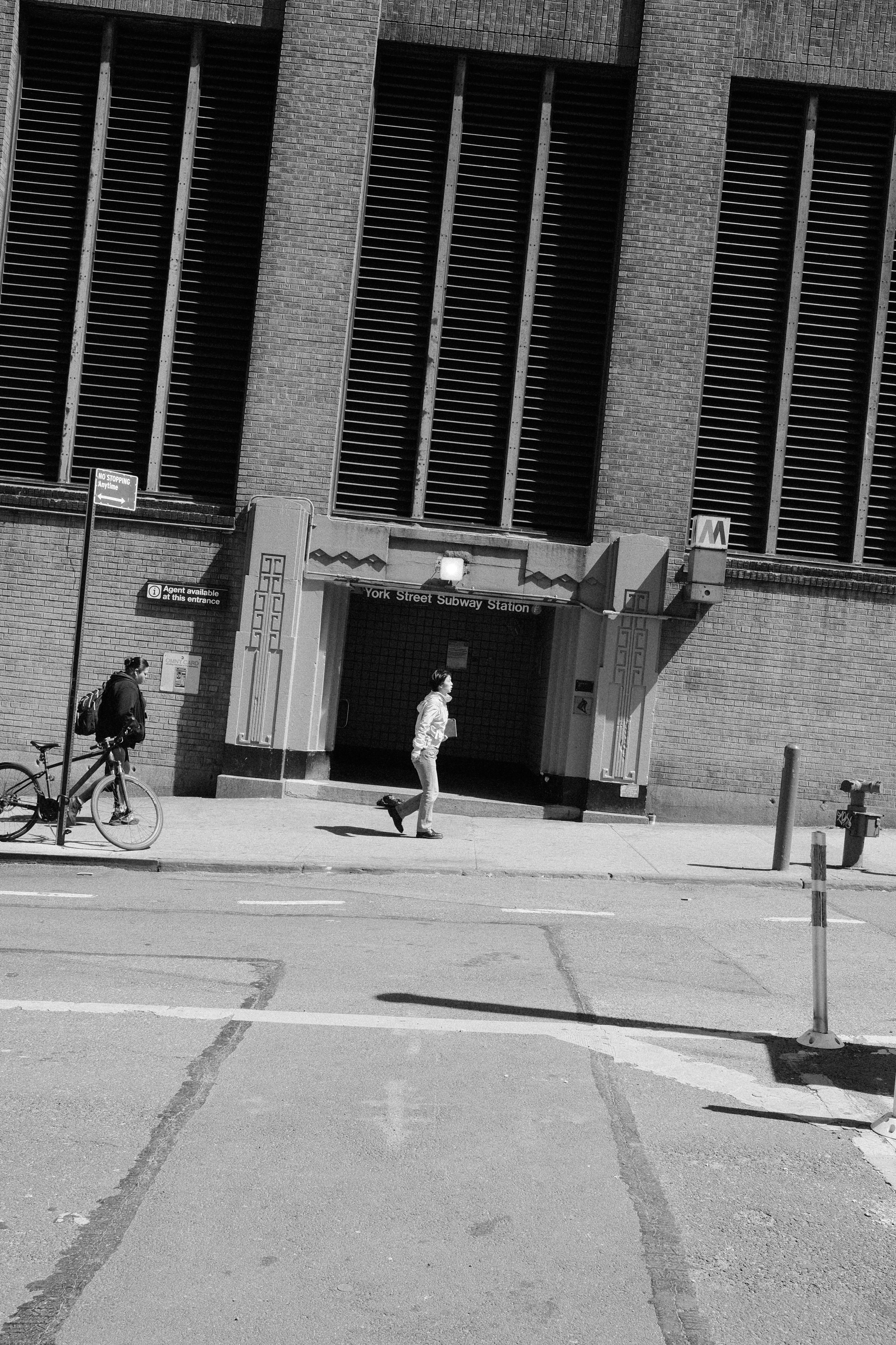Gente y bicicleta cerca de la entrada de un edificio