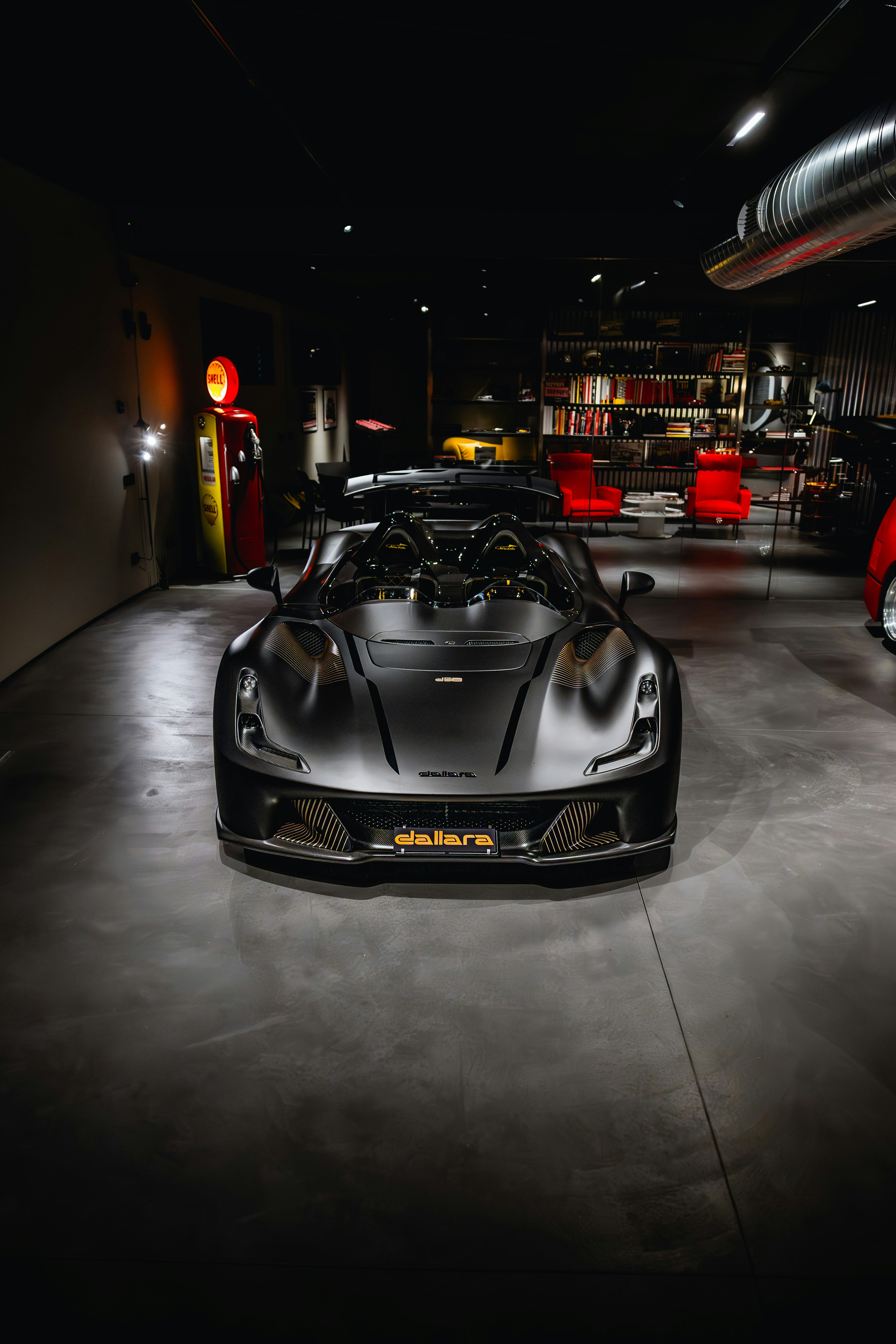 Sleek black sports car in a dimly lit garage.