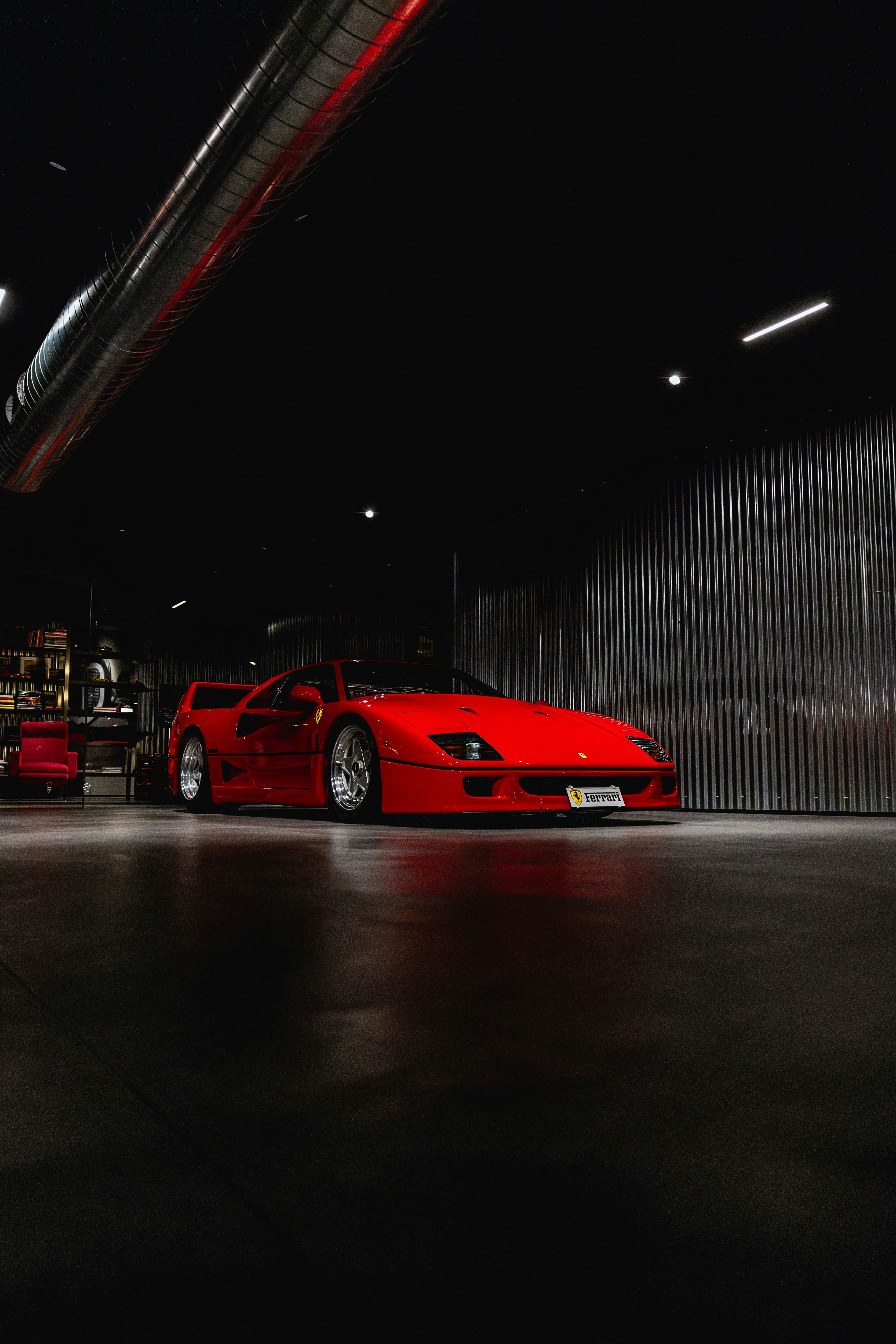 Red ferrari parked in a dark garage