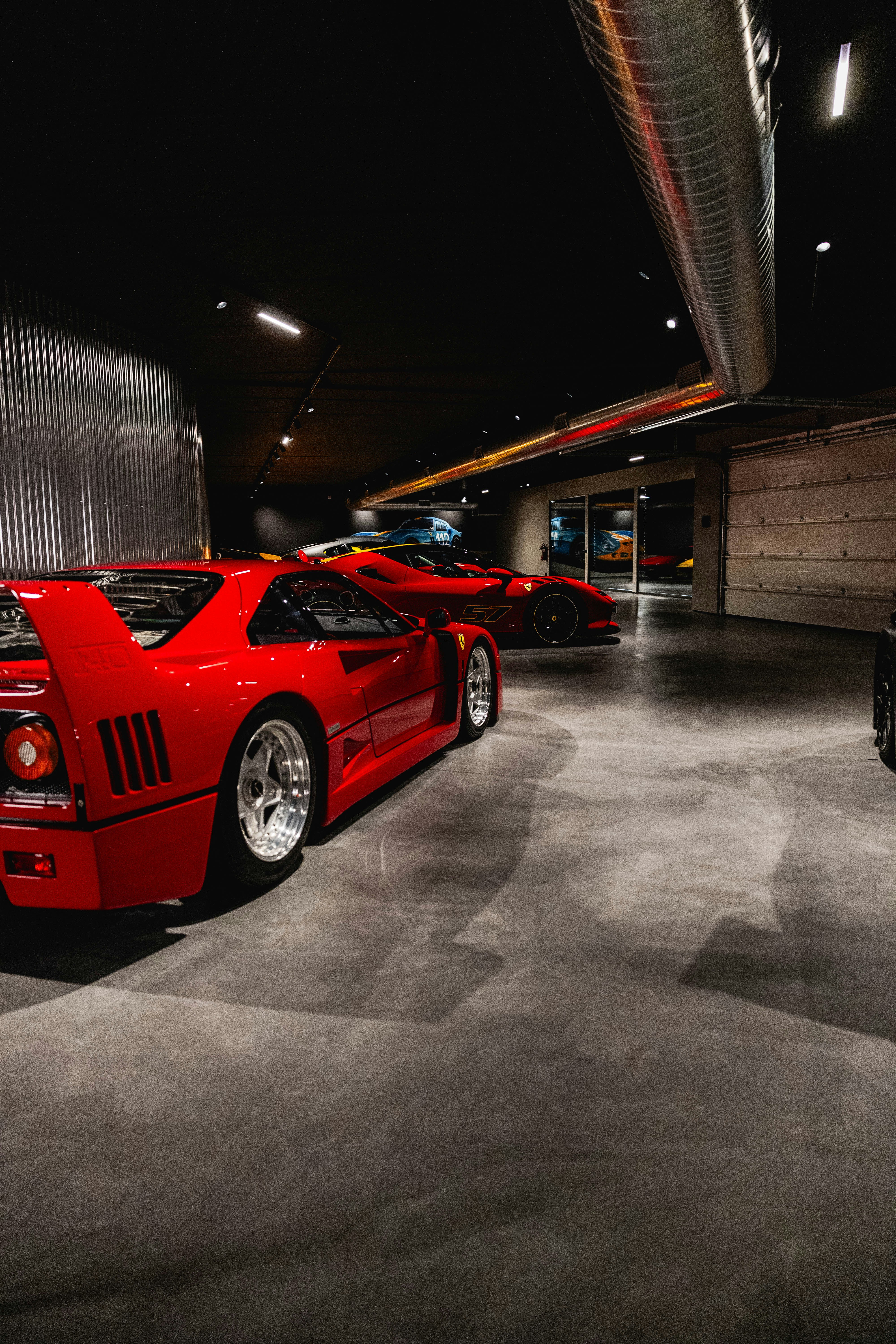 Several red sports cars parked in a modern showroom.