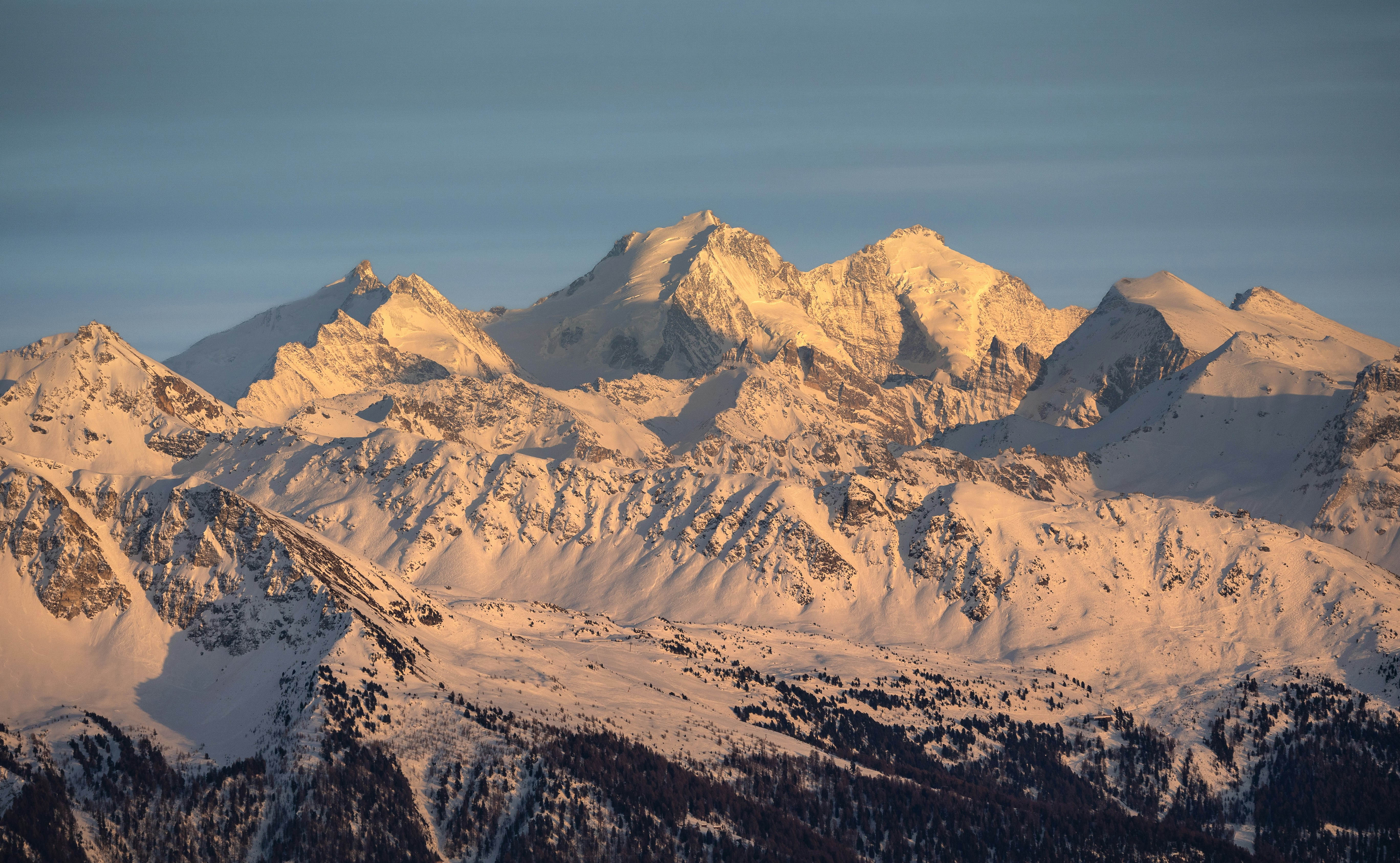 Snow-covered mountains bathed in golden sunlight