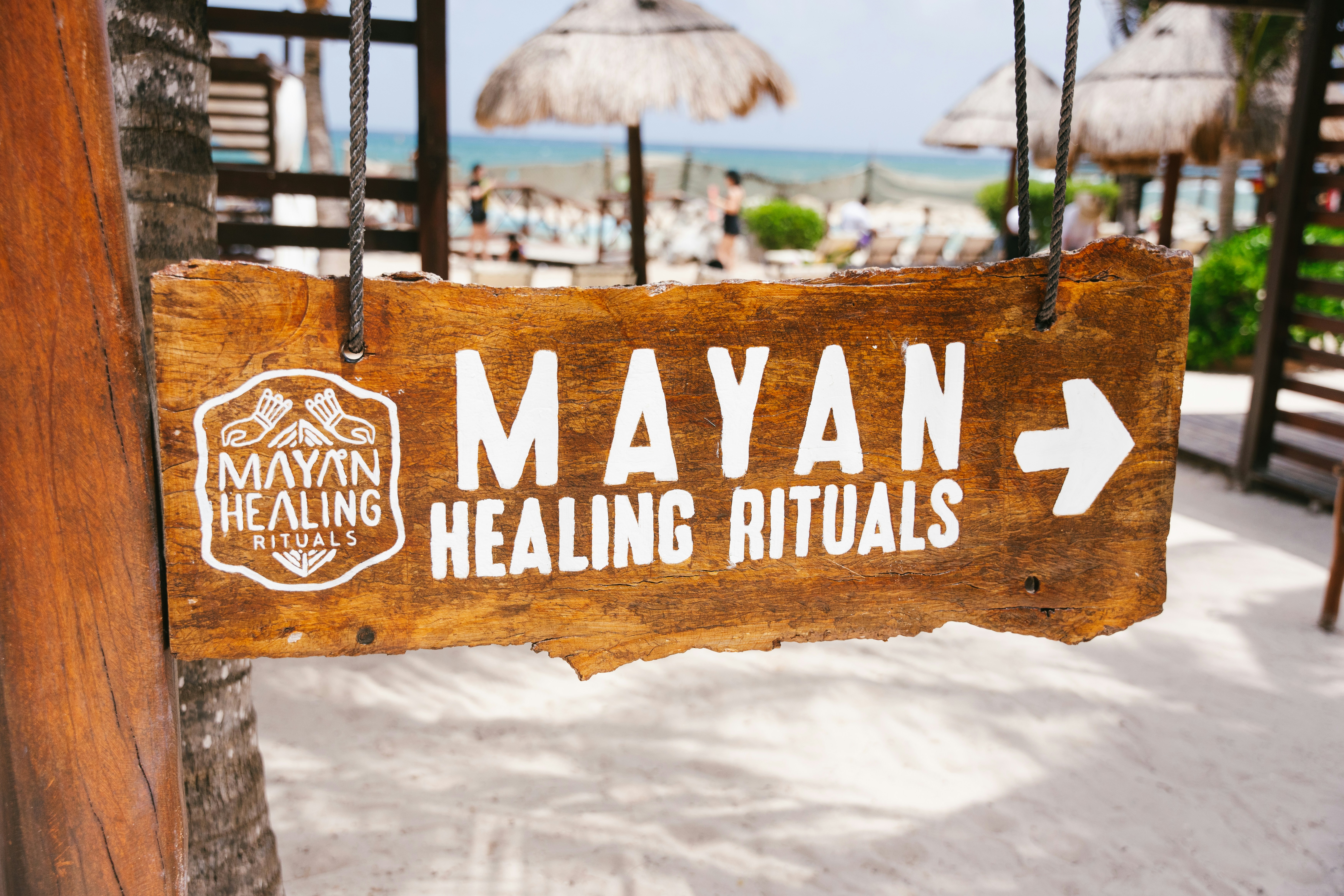 Wooden sign for mayan healing rituals points right