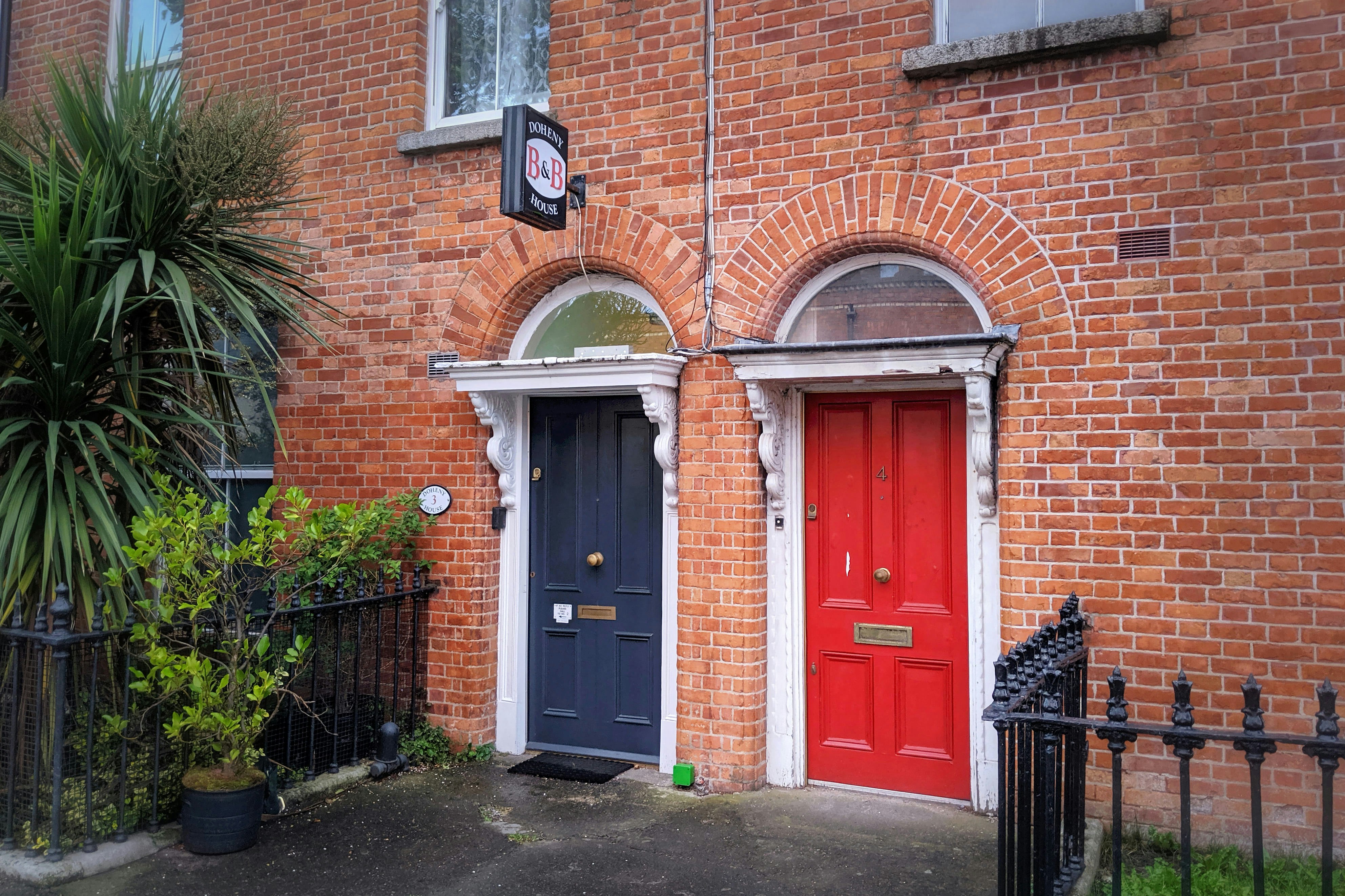Two colorful doors on a brick building