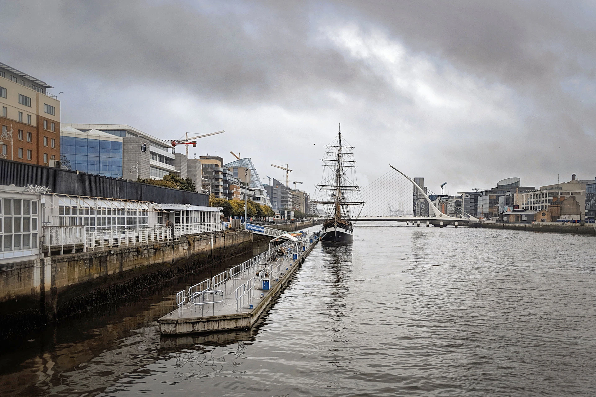 River Liffey quays in Dublin with a tall ship and the Samuel Beckett Bridge