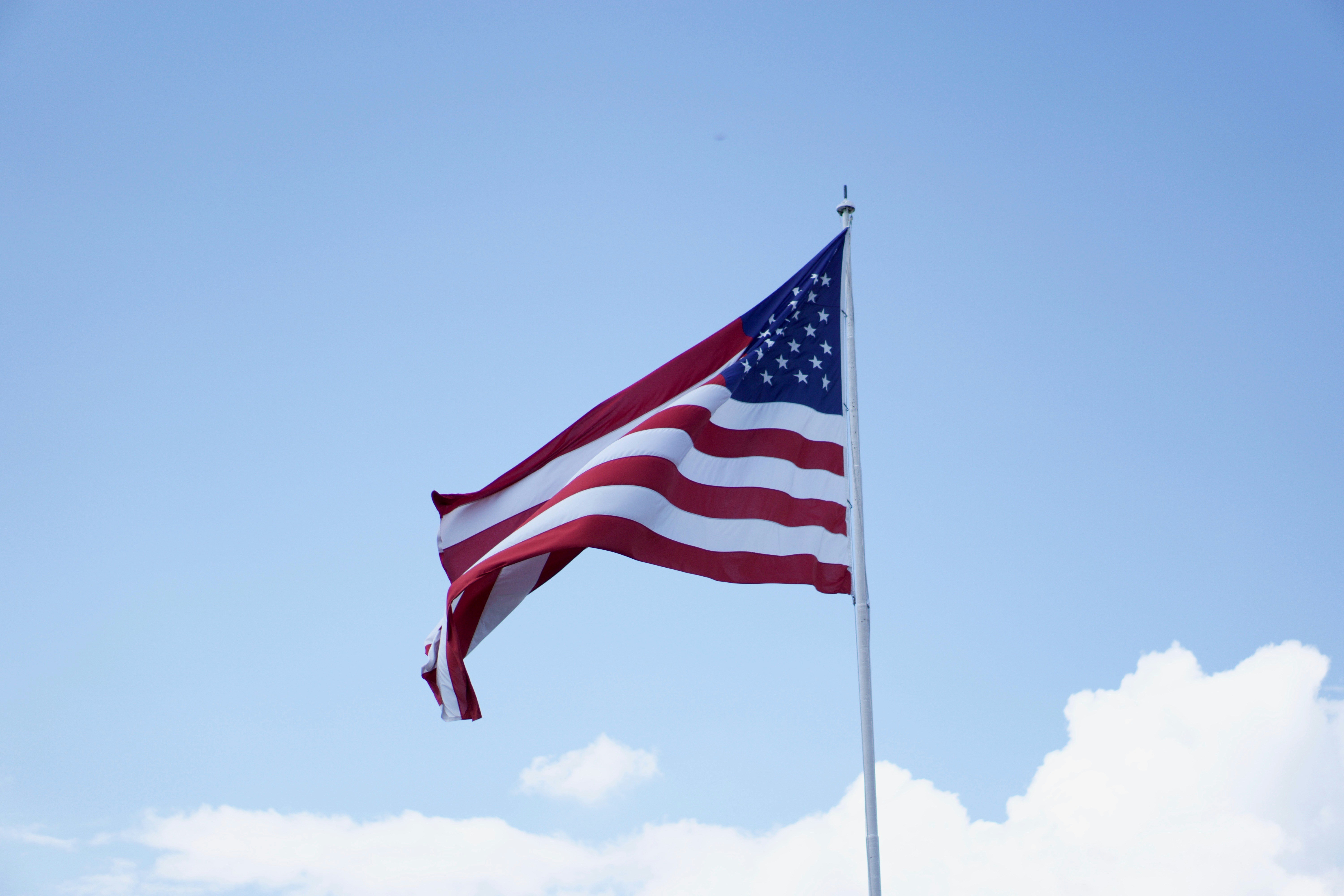 American flag waving against a blue sky.