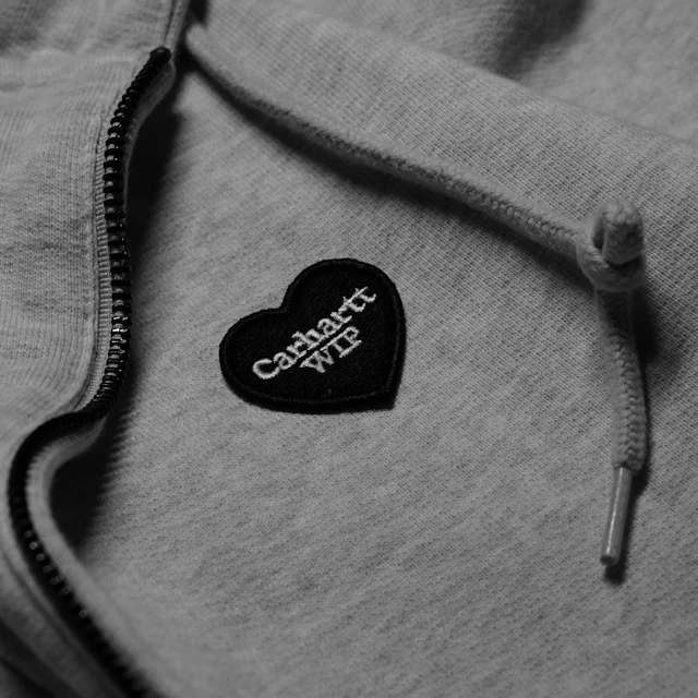 A grey hoodie with a heart-shaped Carhartt WIP patch
