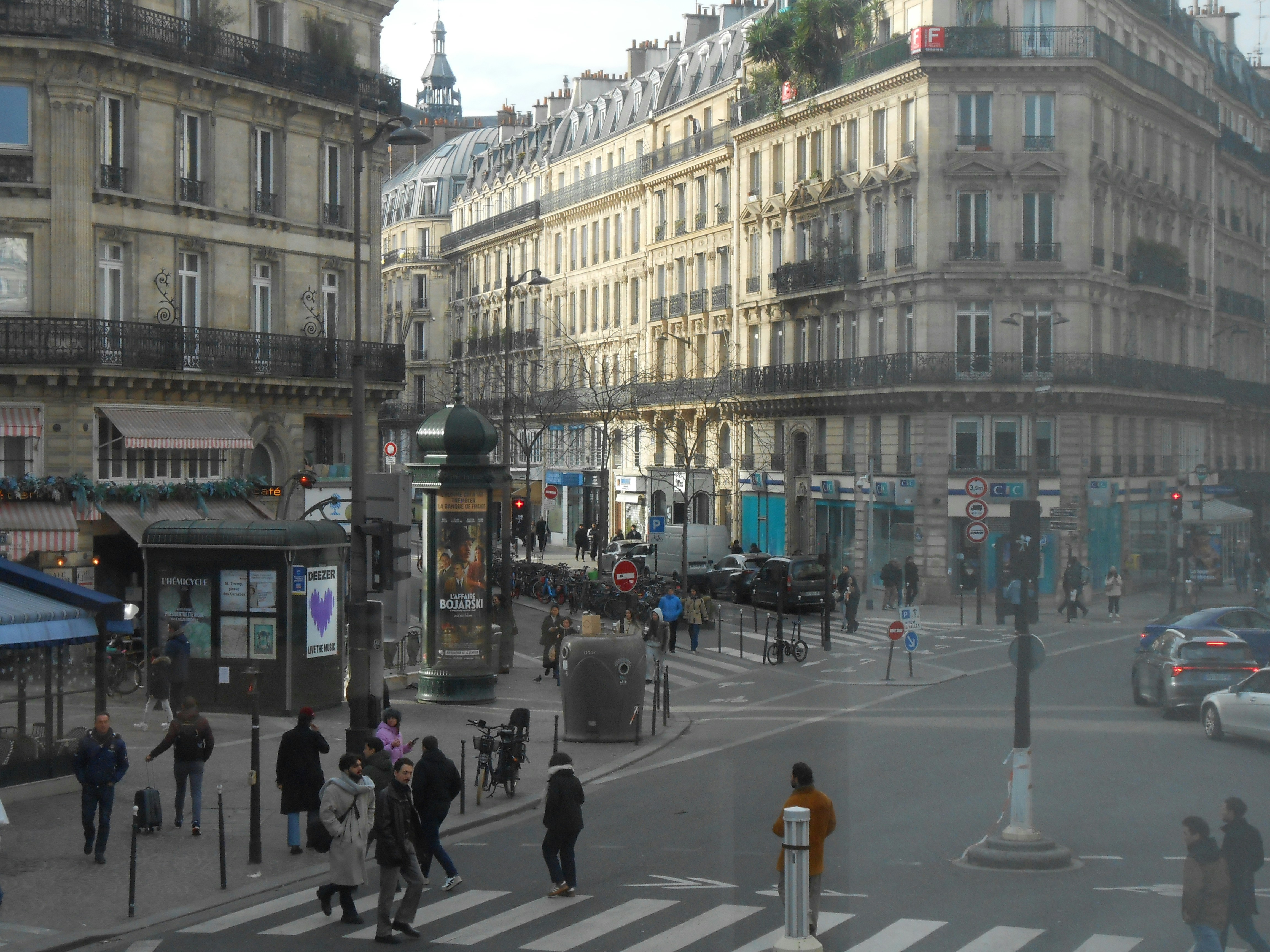 Busy street scene with pedestrians and buildings in paris.