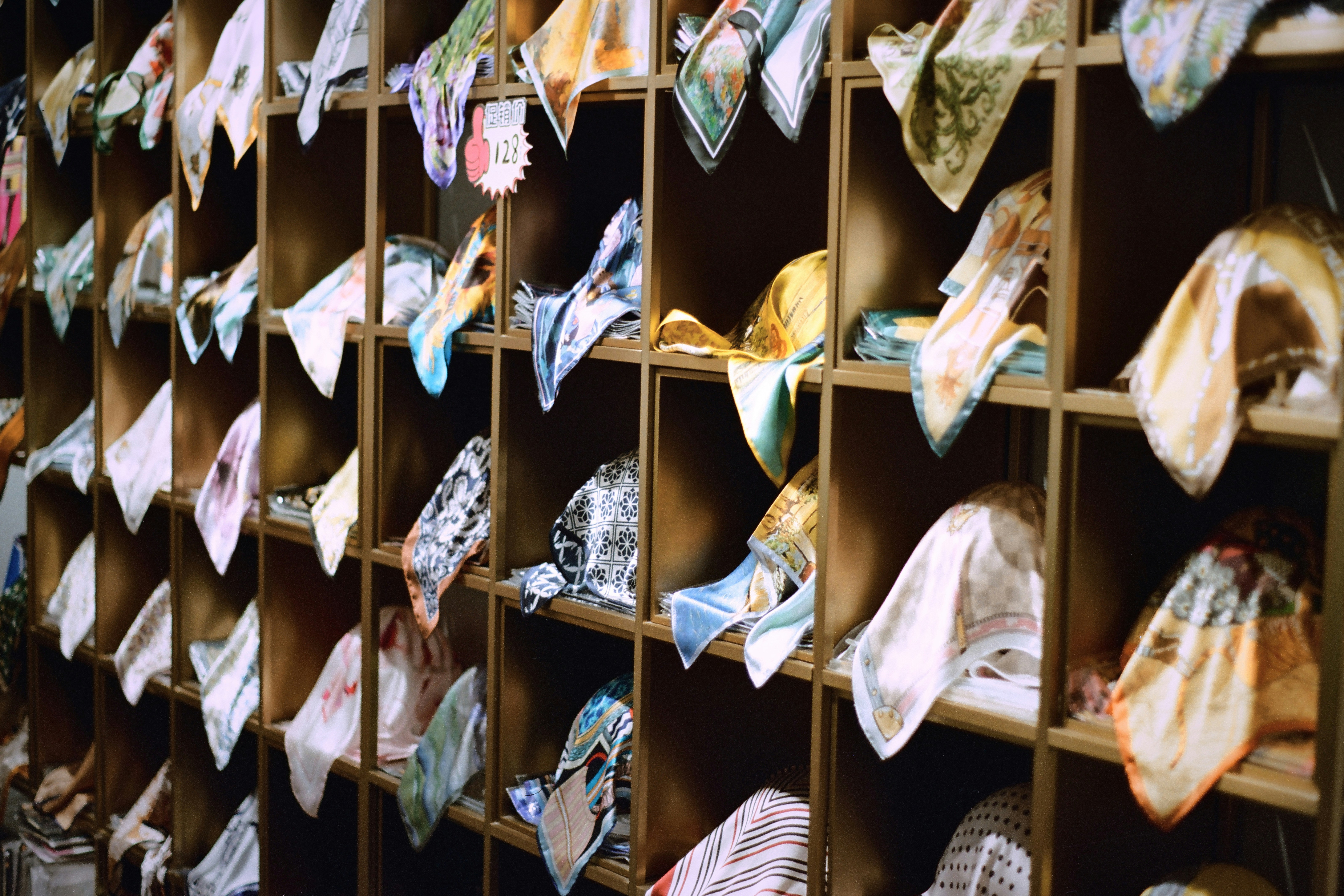 Colorful handkerchiefs neatly folded on wooden shelves