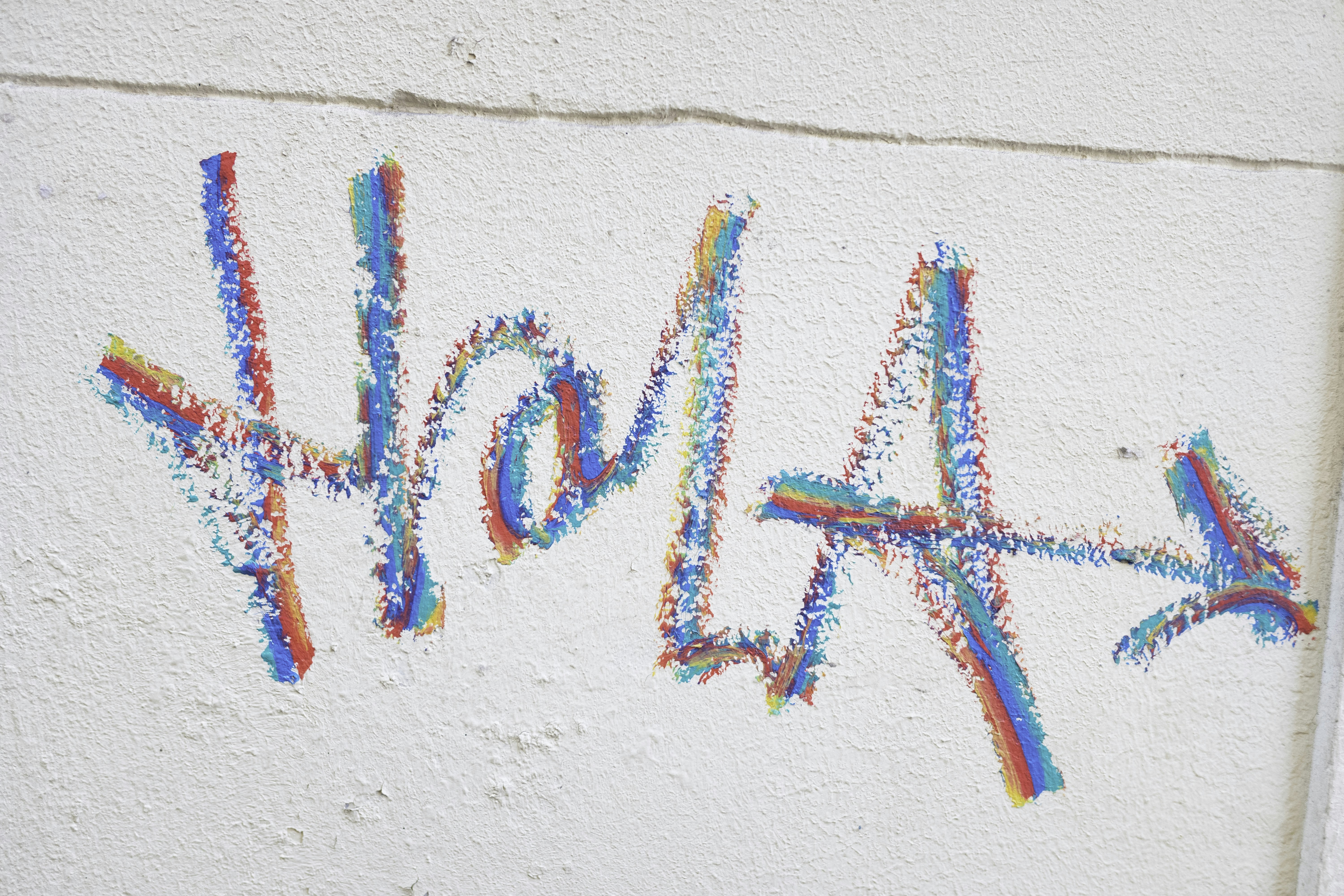 壁に描かれたカラフルなチョークの「hola」の絵
