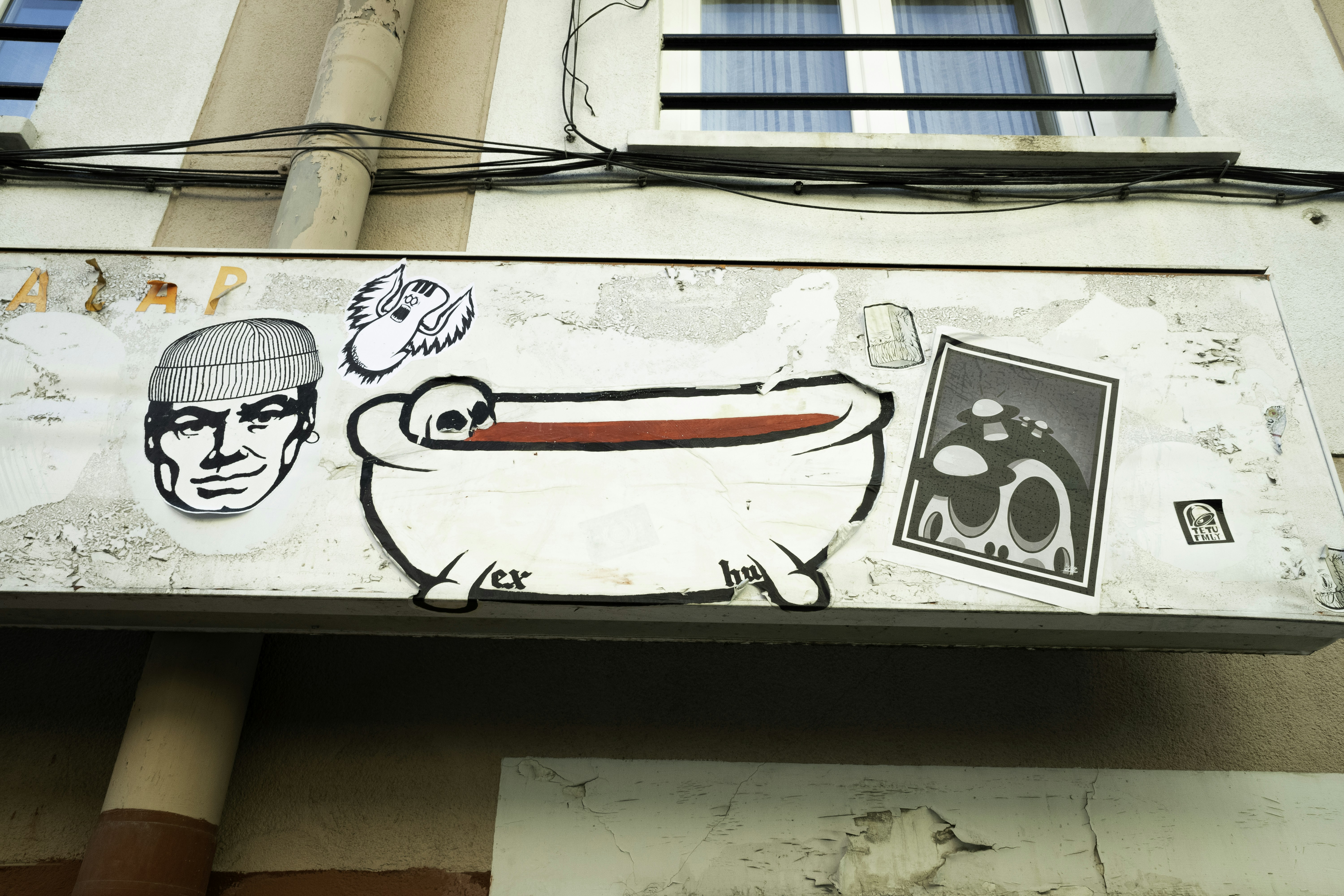 Seni grafiti di eksterior bangunan dengan ilustrasi bak mandi.