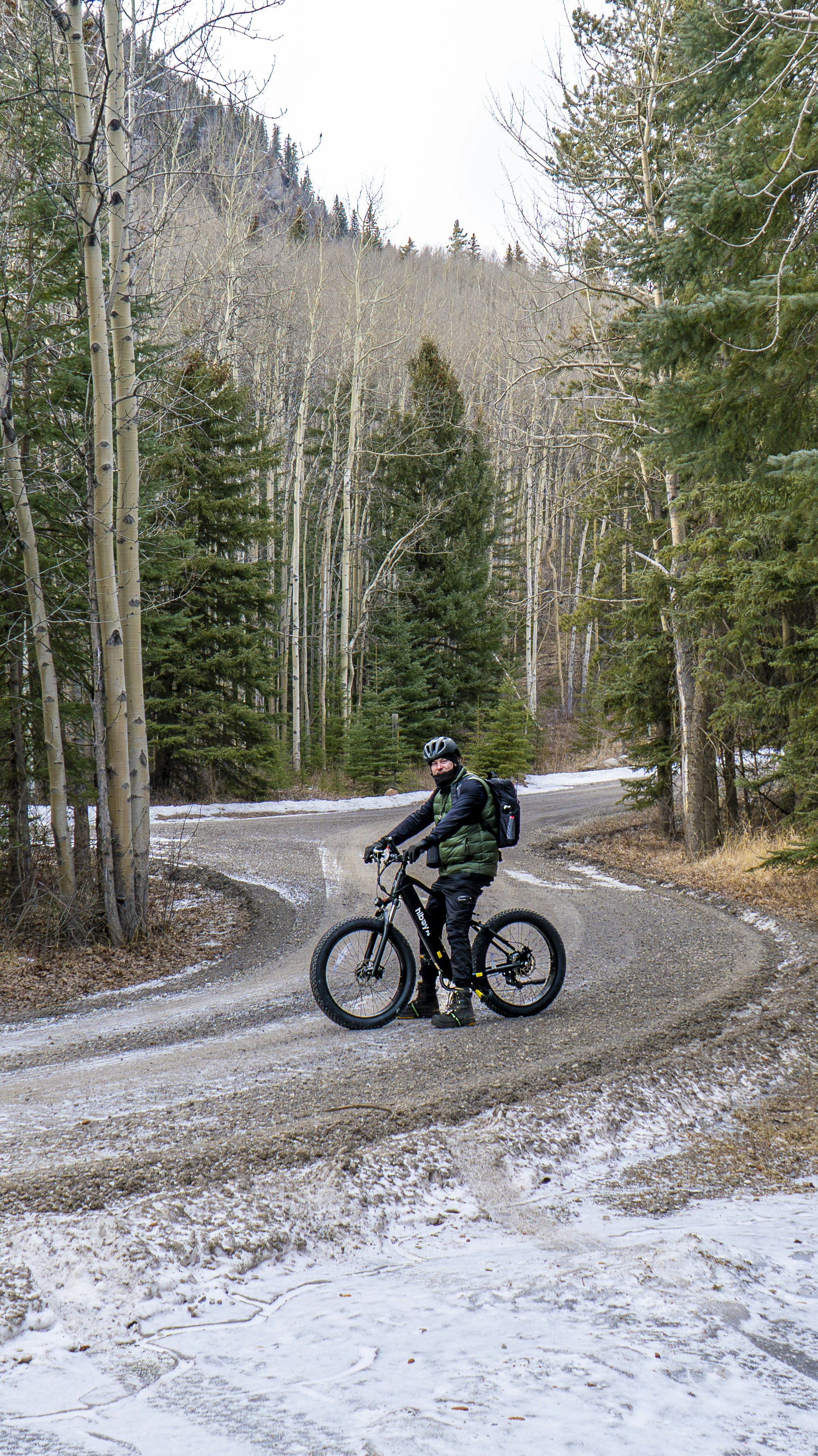 Man on fat tire bike on snowy forest road