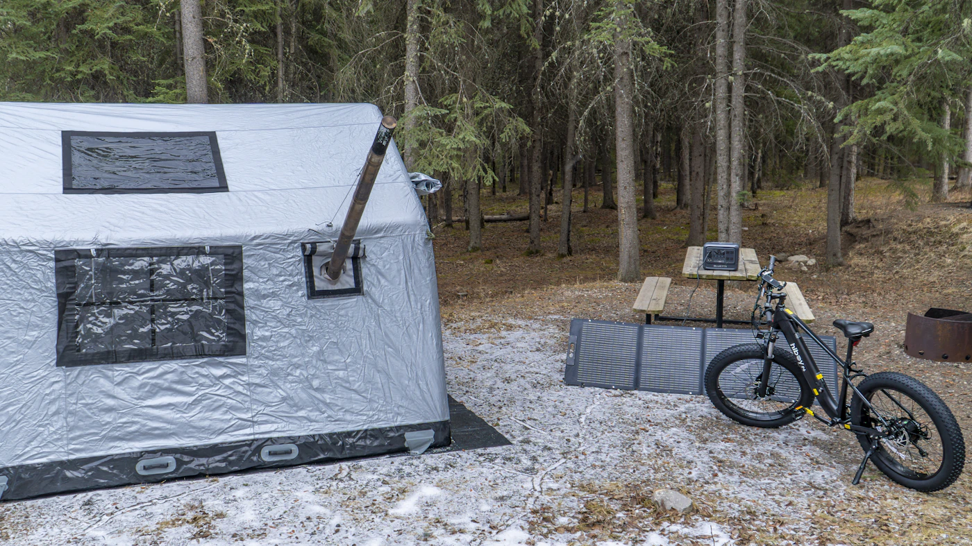 Tent with portable power and charging equipment at a forest campsite