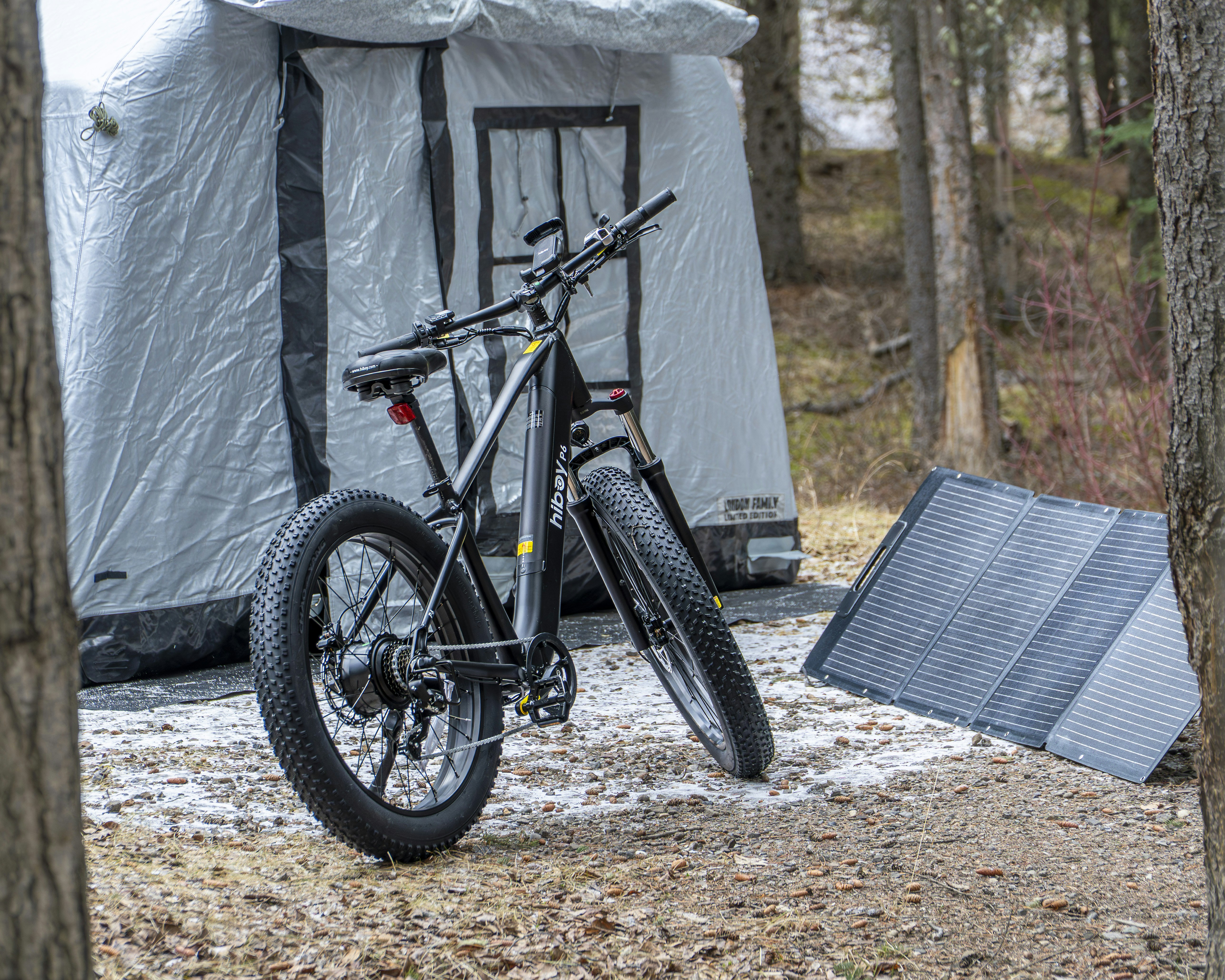 Electric bicycle parked near a tent and solar panel