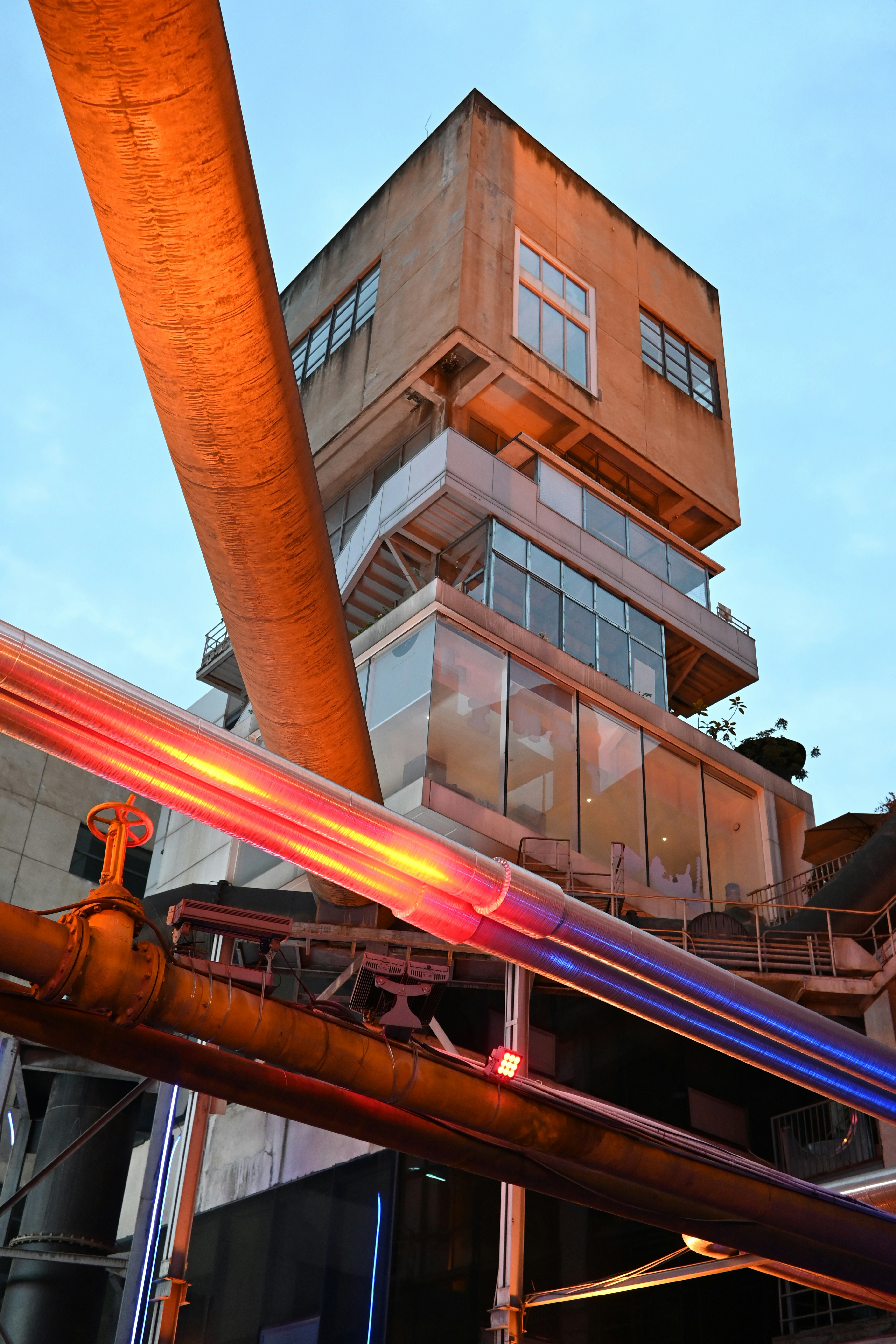 Edificio industrial con tuberías y ventanas iluminadas