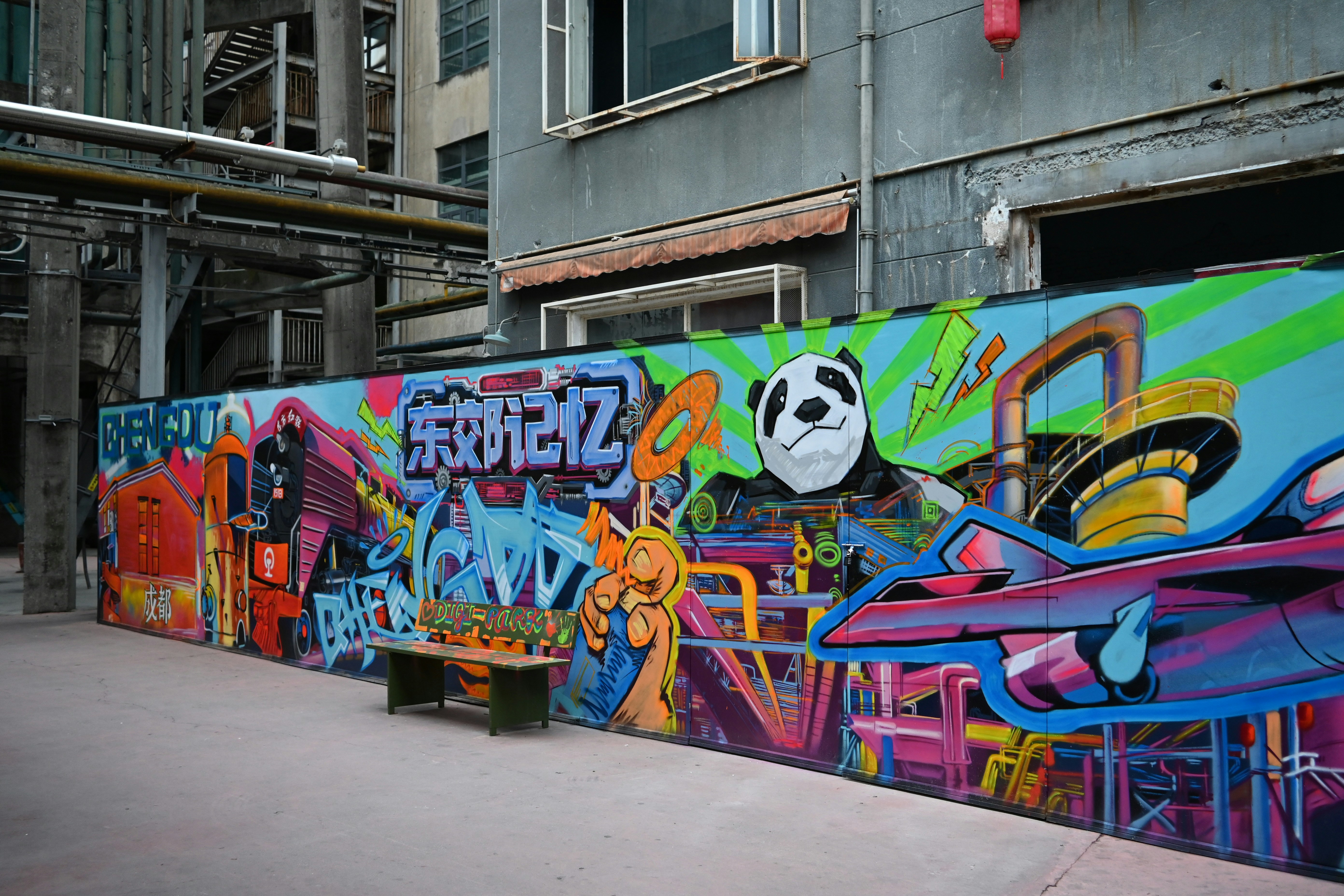 Un colorido arte de graffiti cubre una larga pared con un panda.