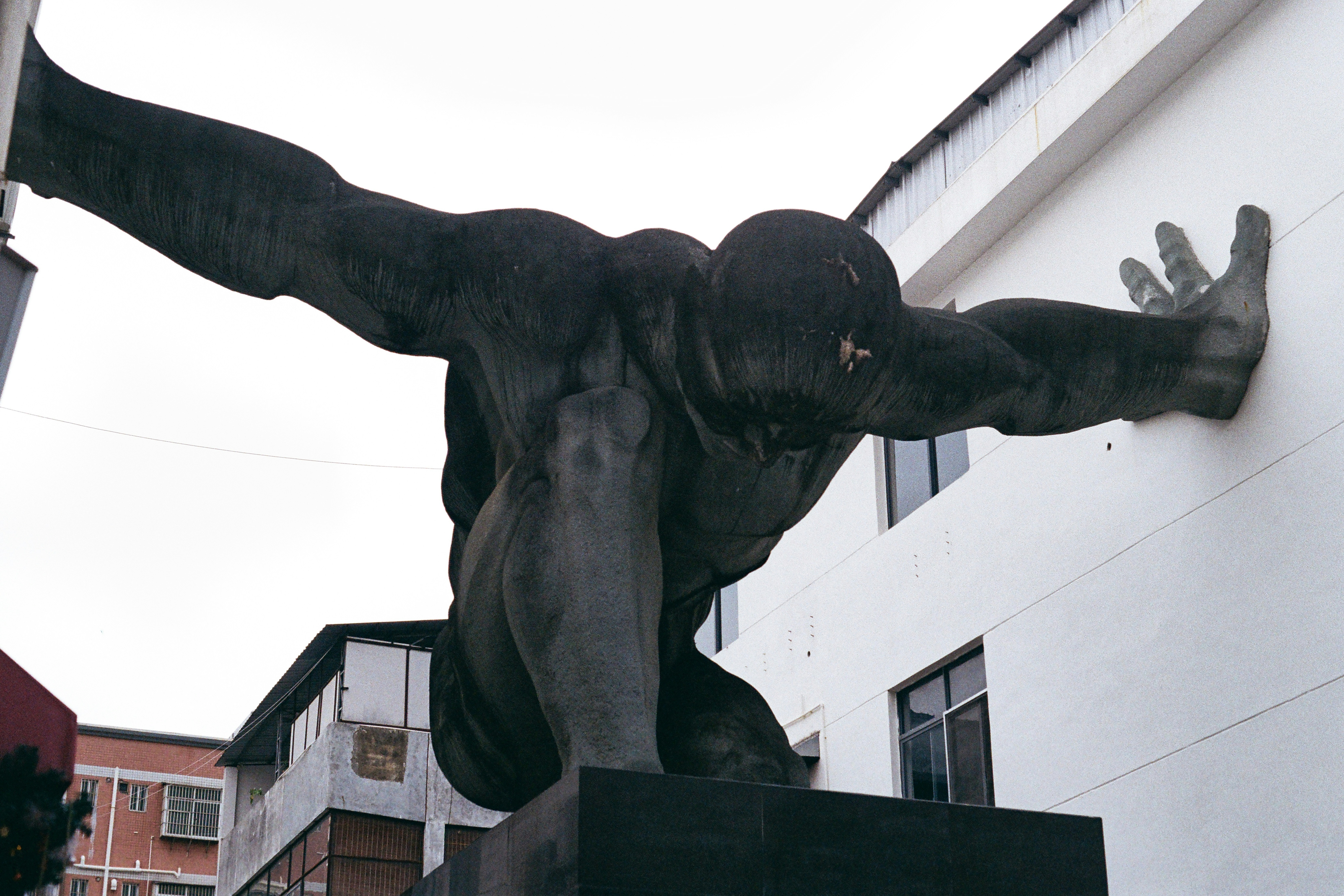 A large statue of a man pushing a wall