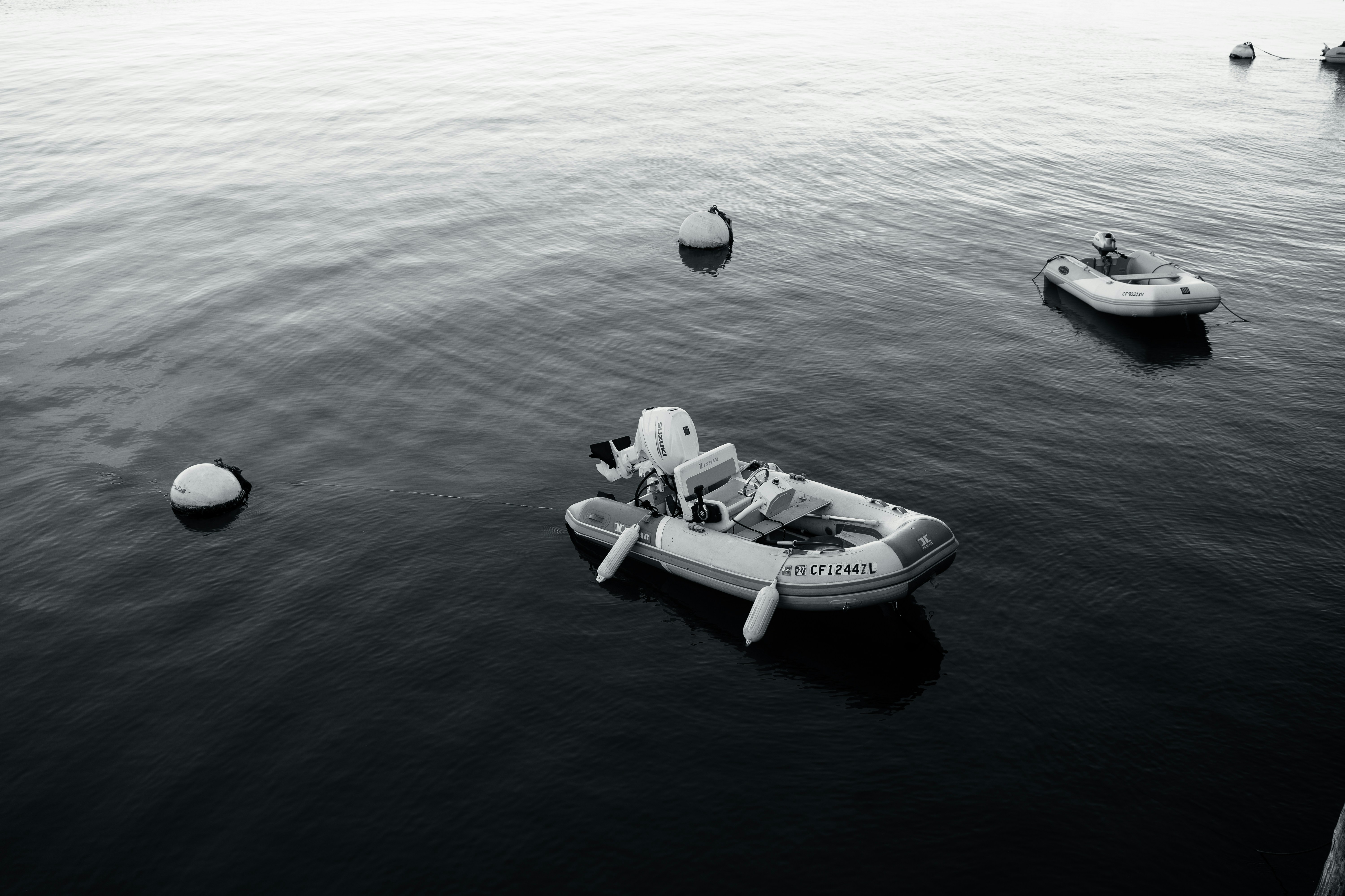 Two inflatable boats float on calm water