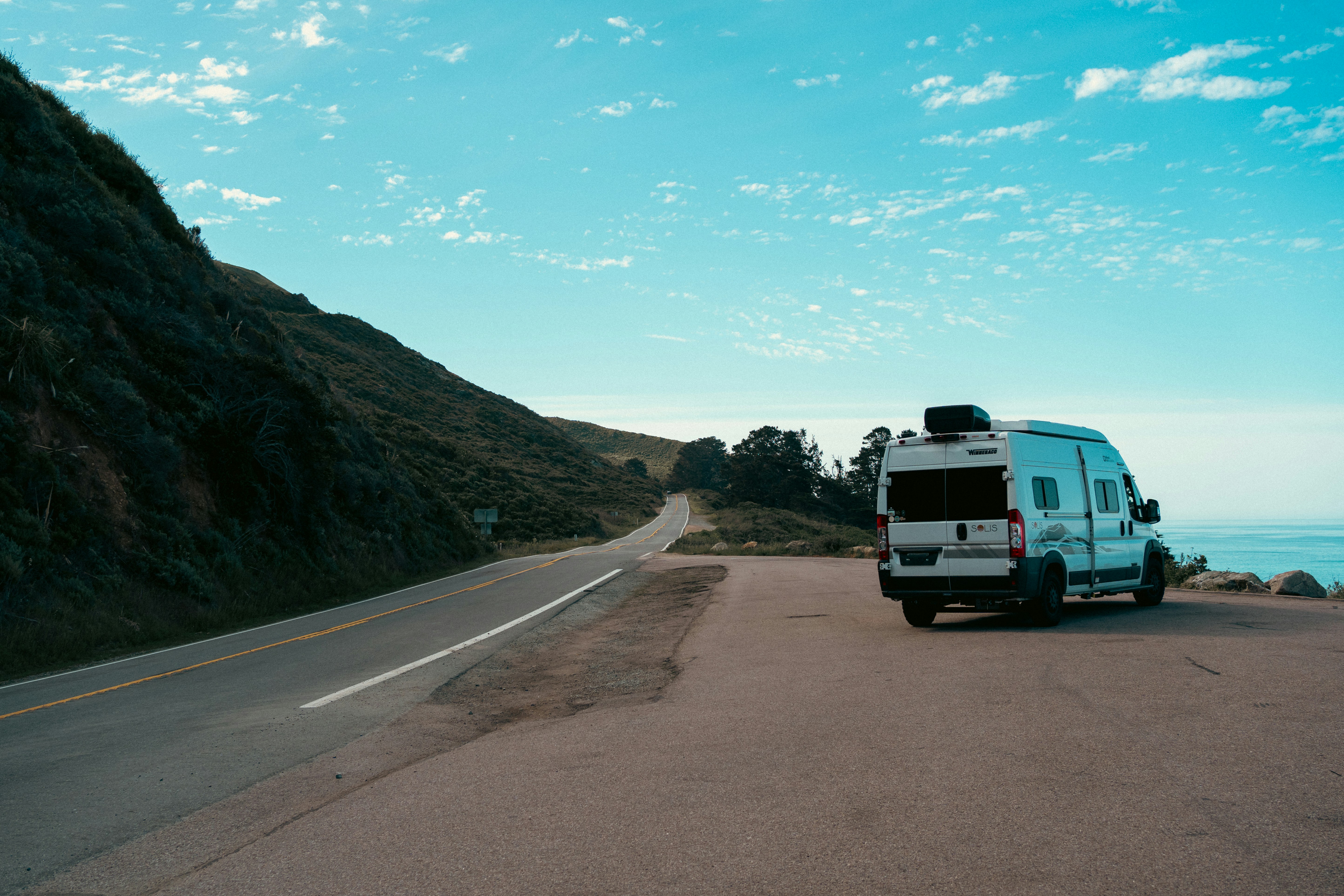 Camper van parked by the ocean road