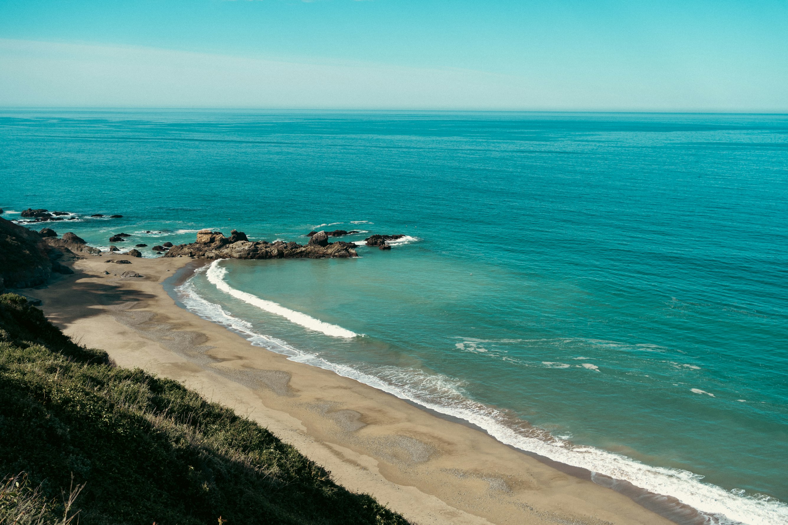 The stone facade and bell tower of an old European church against a clear blue sky