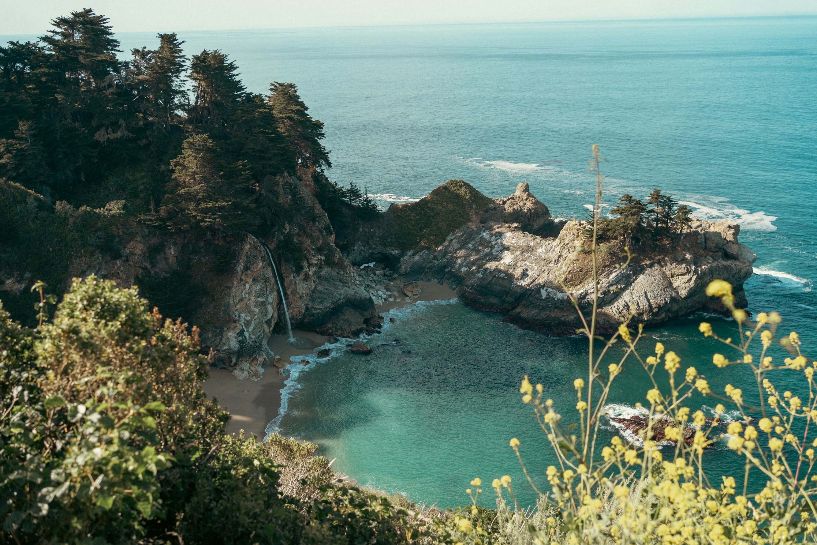 The sun setting over a calm sea, casting a golden glow on the water and horizon