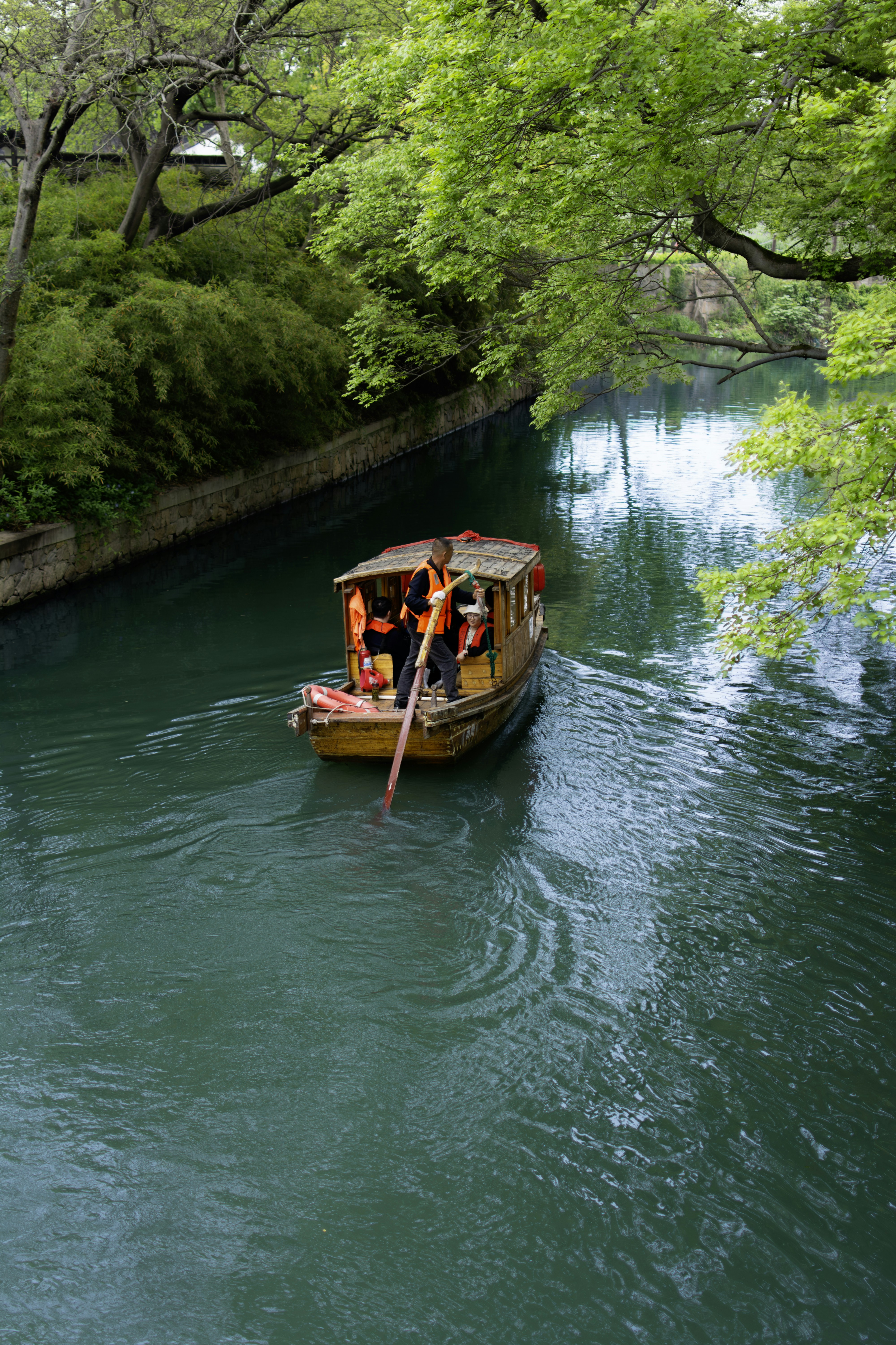Bateau avec des gens naviguant sur un canal vert.