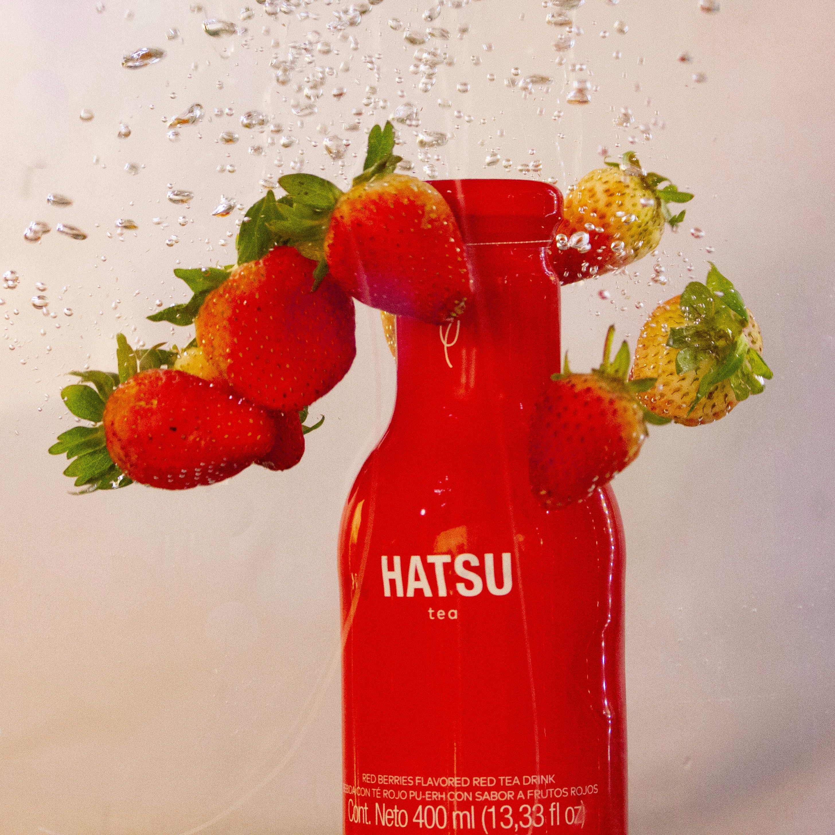 Fragole e una bottiglia rossa di tè hatsu