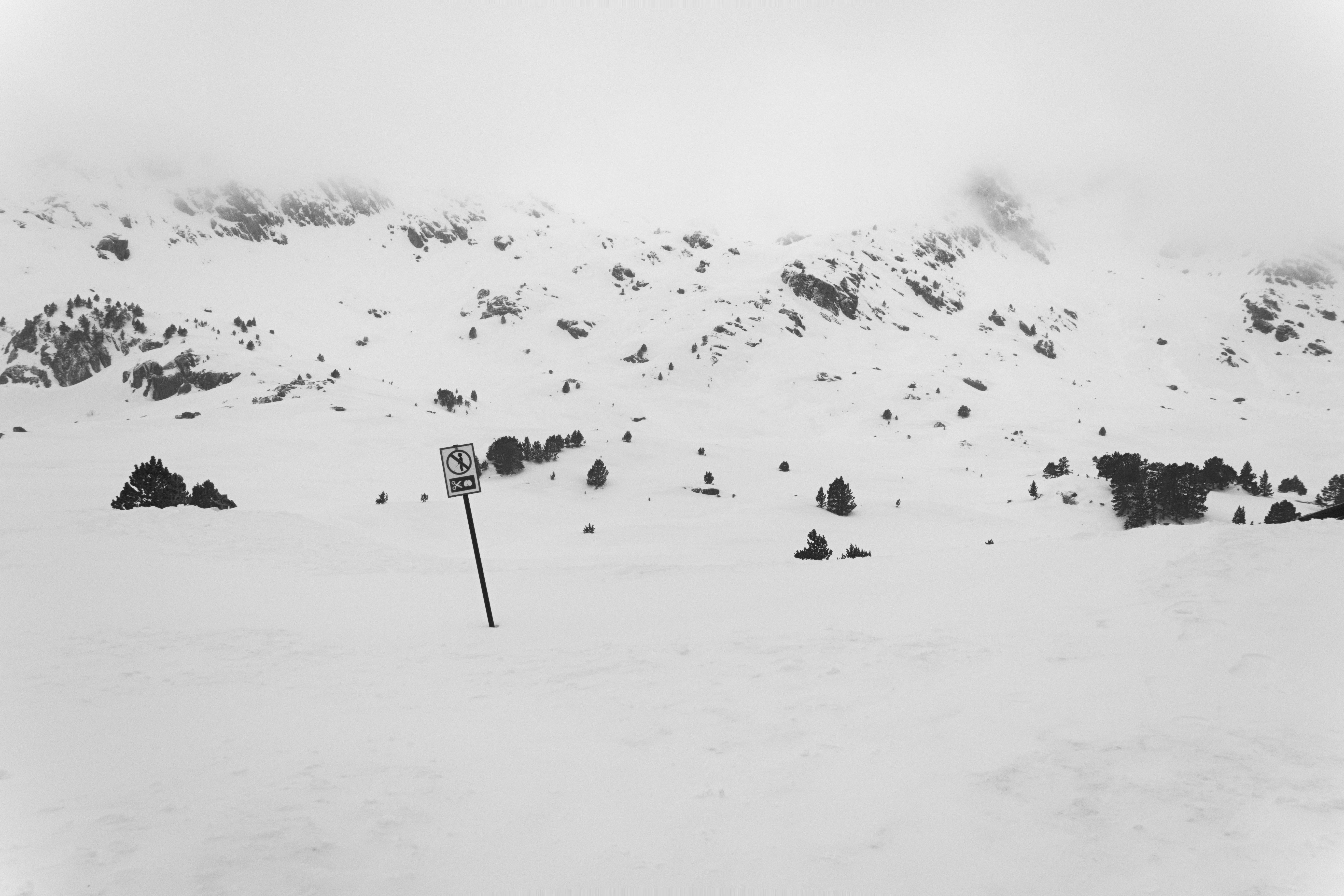 Schneebedeckter Berghang mit Warnschild