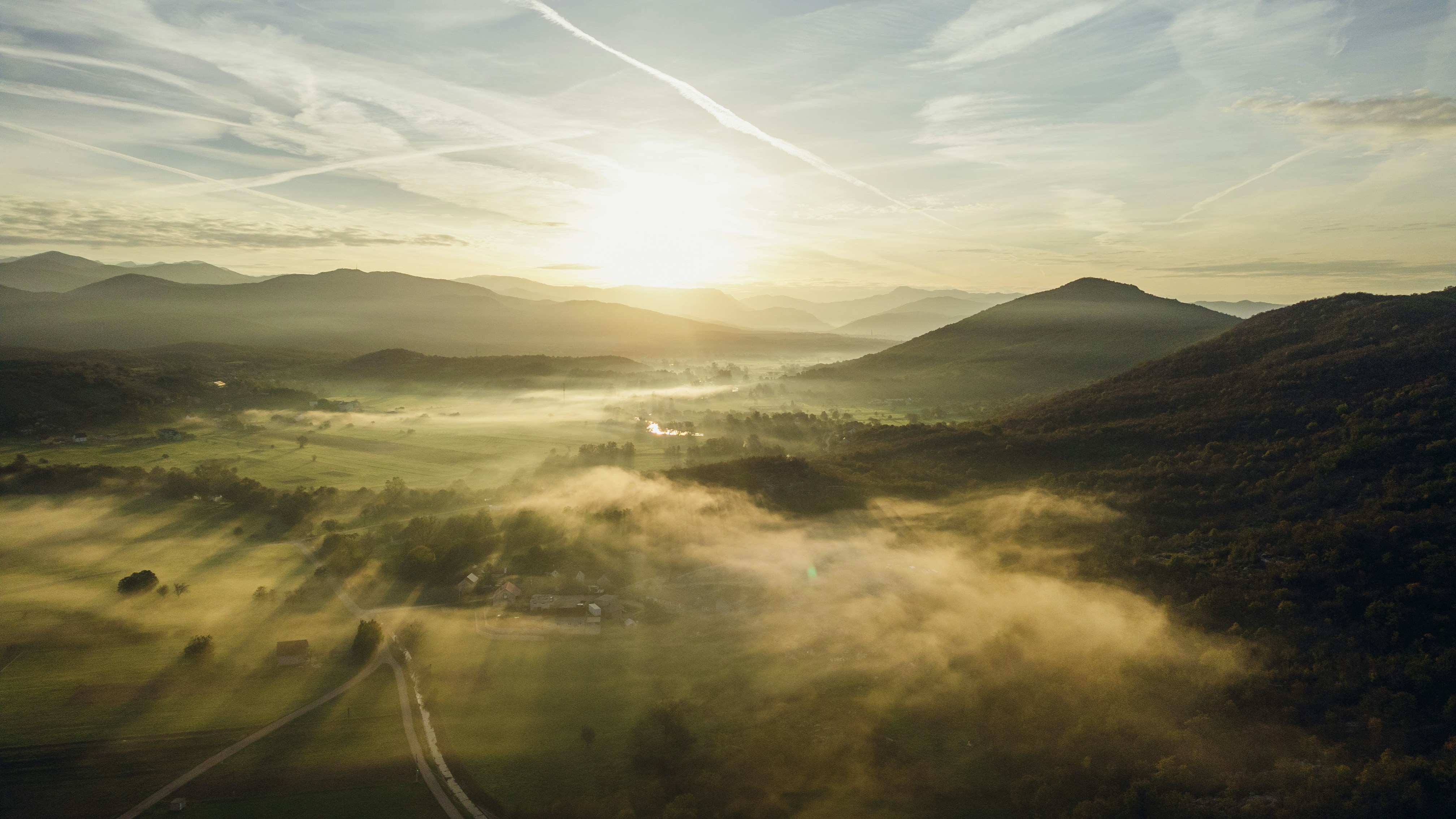 Amanecer sobre montañas y valles brumosos