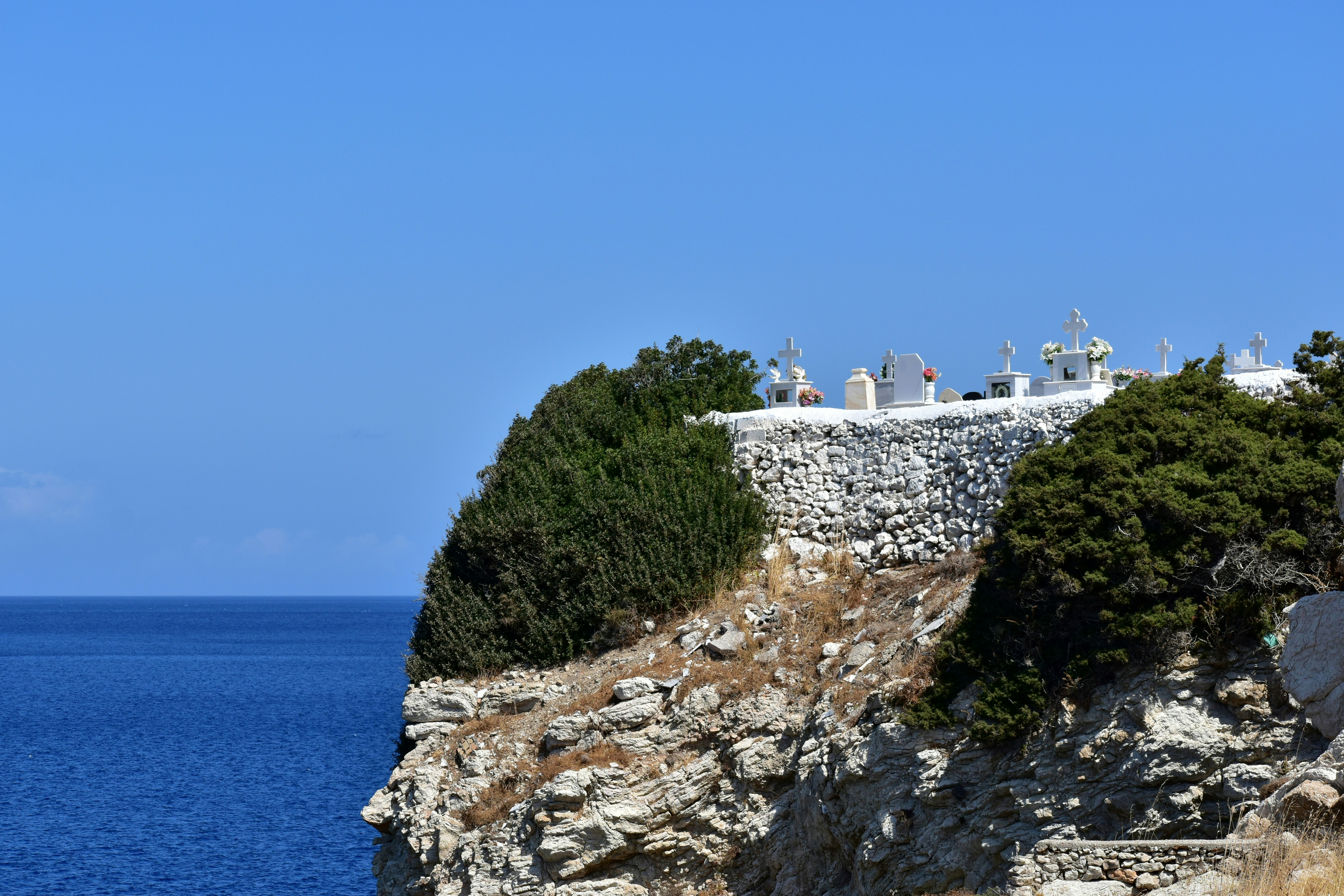Estructuras blancas en un acantilado rocoso con vistas al océano.