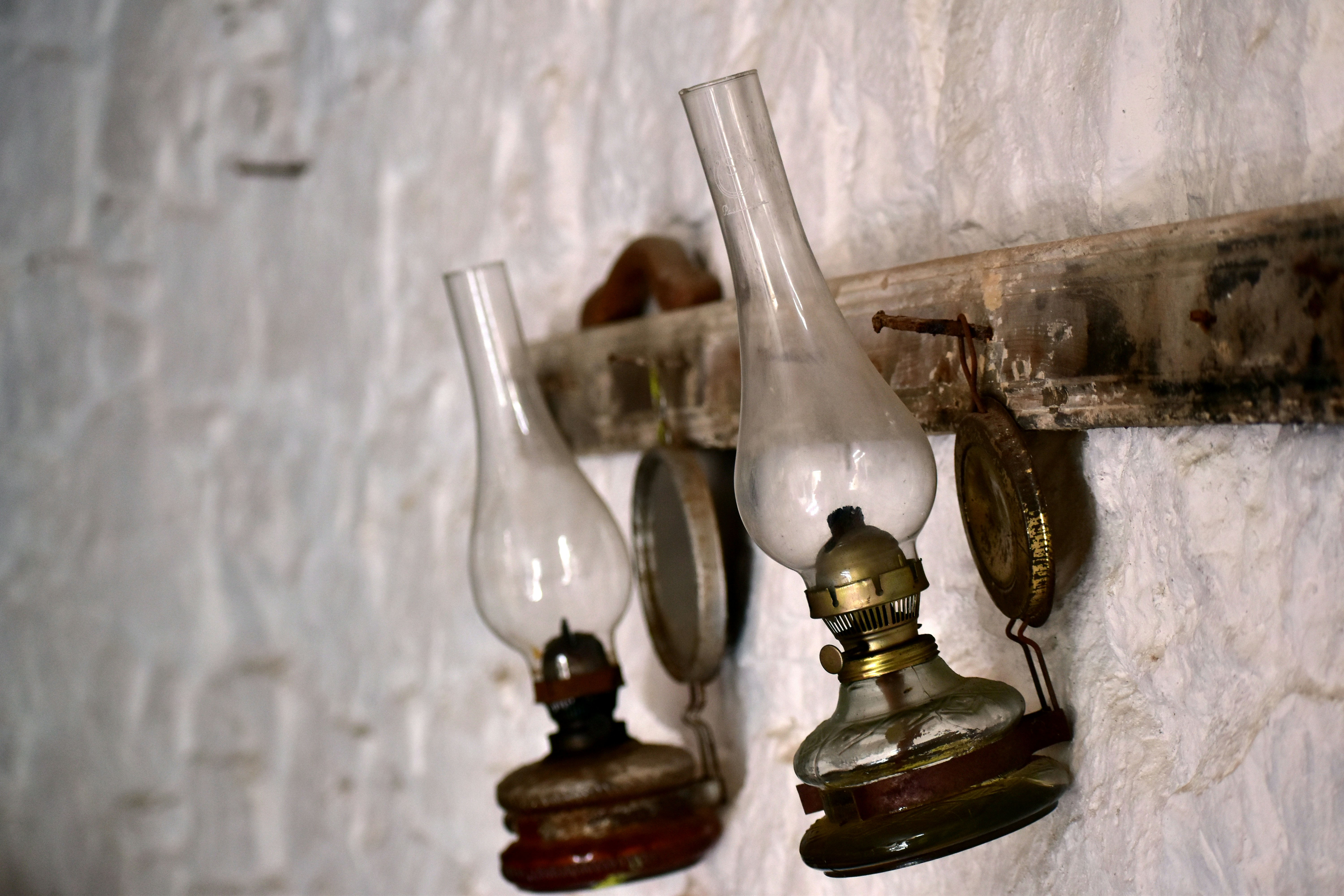 Dos lámparas de aceite antiguas colgadas en una pared
