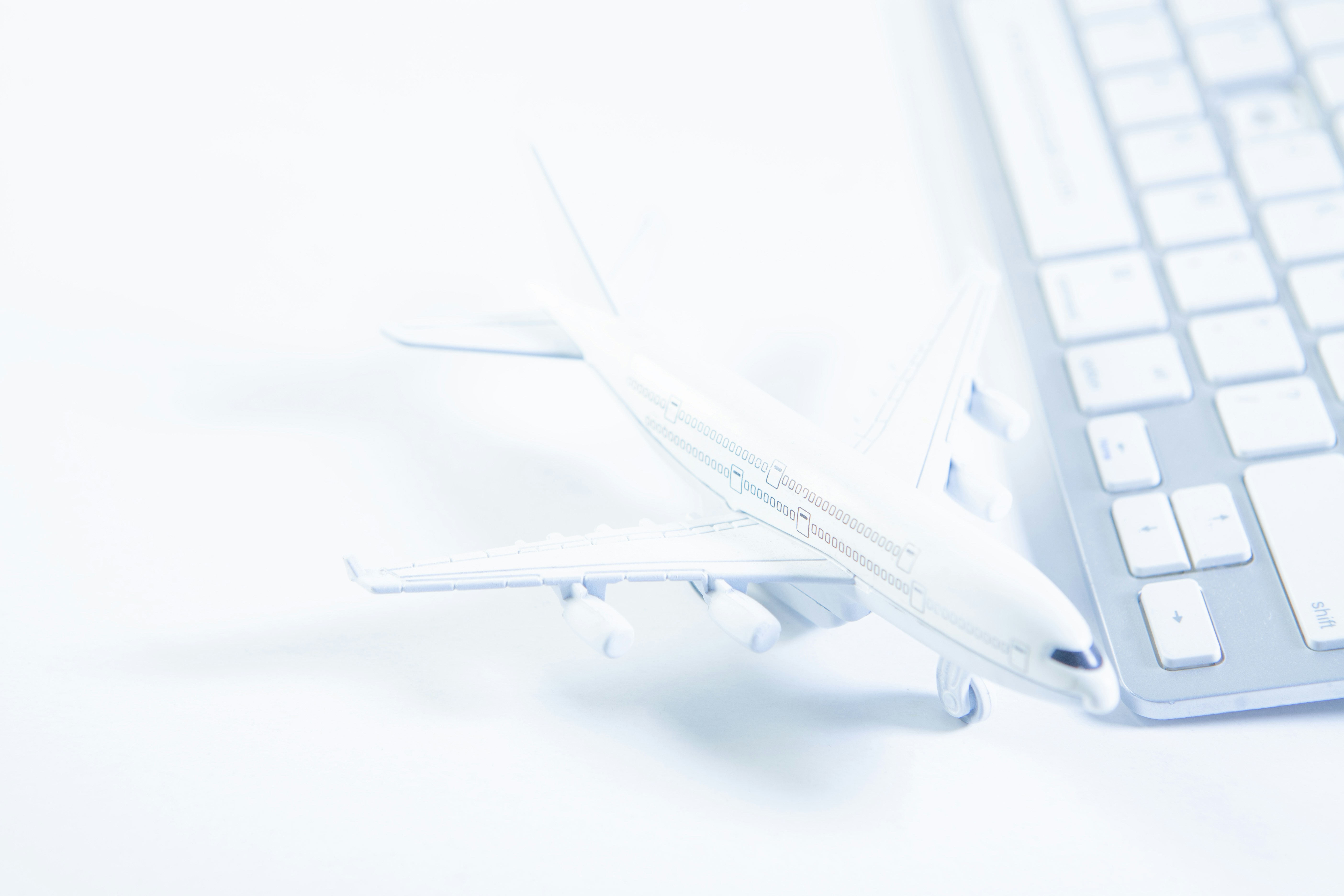 A white airplane model next to a computer keyboard.