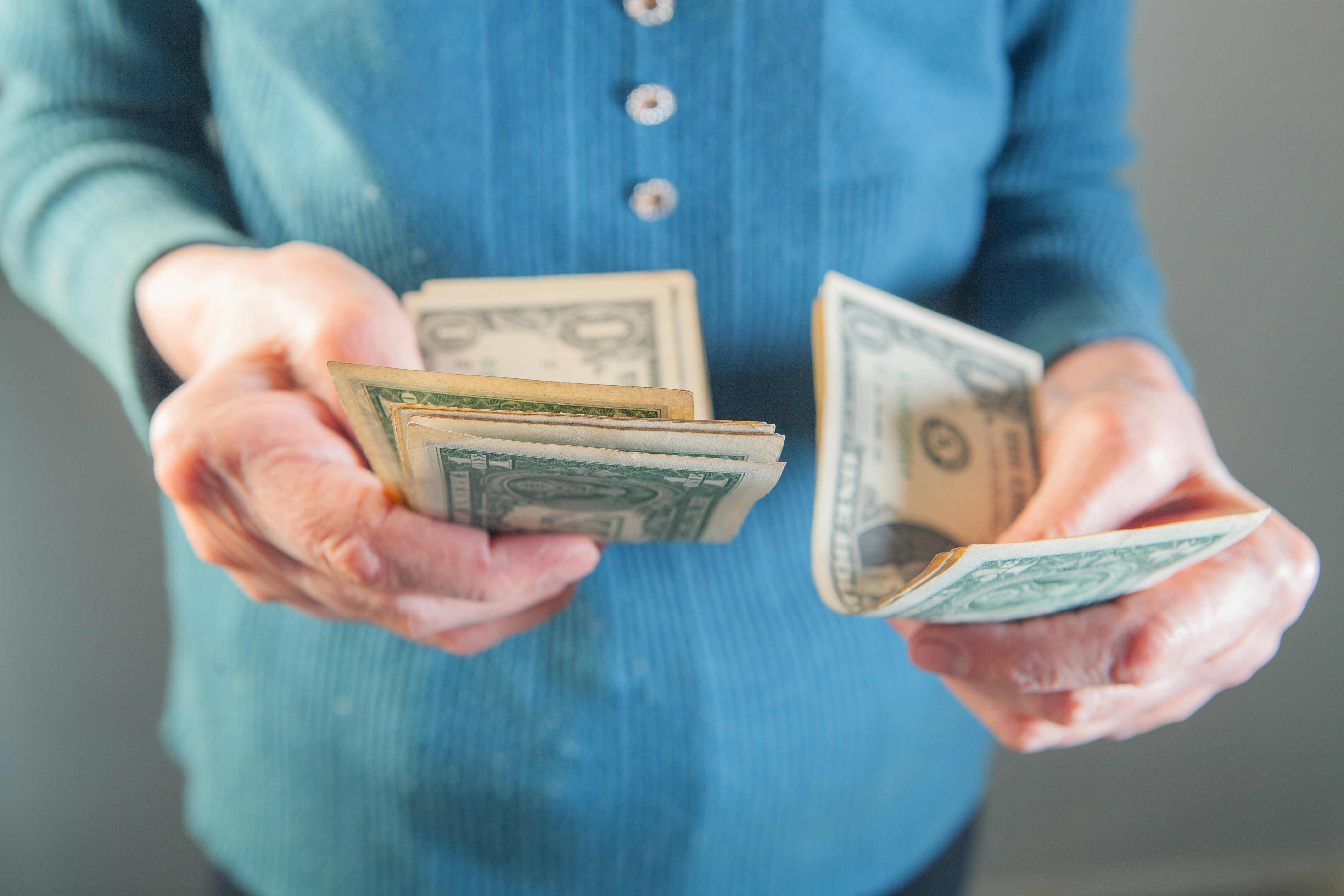 Hands holding us dollar bills