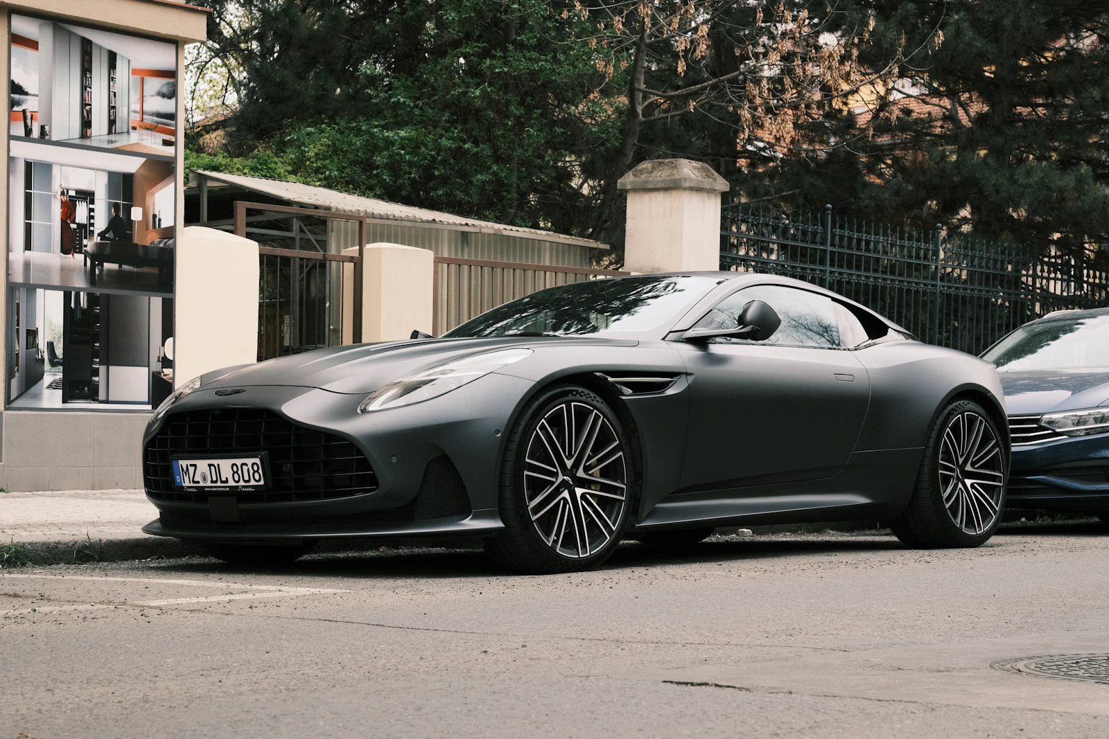 Matte gray Aston Martin DB12 parked on a city street