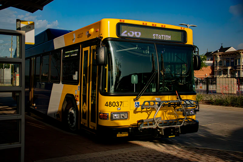 A yellow public transit bus parked at a station.