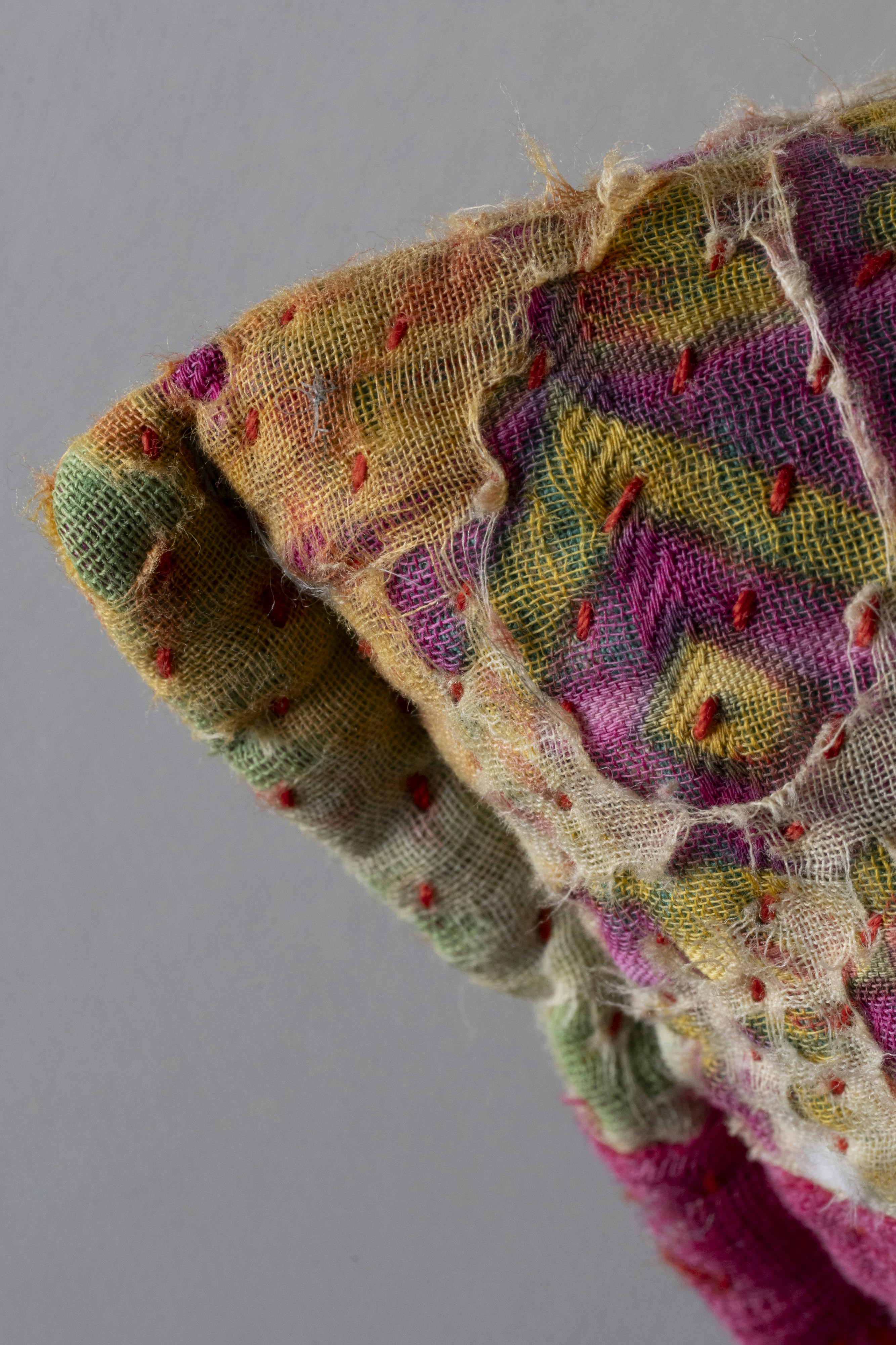 Close-up of colorful embroidered fabric with frayed edges