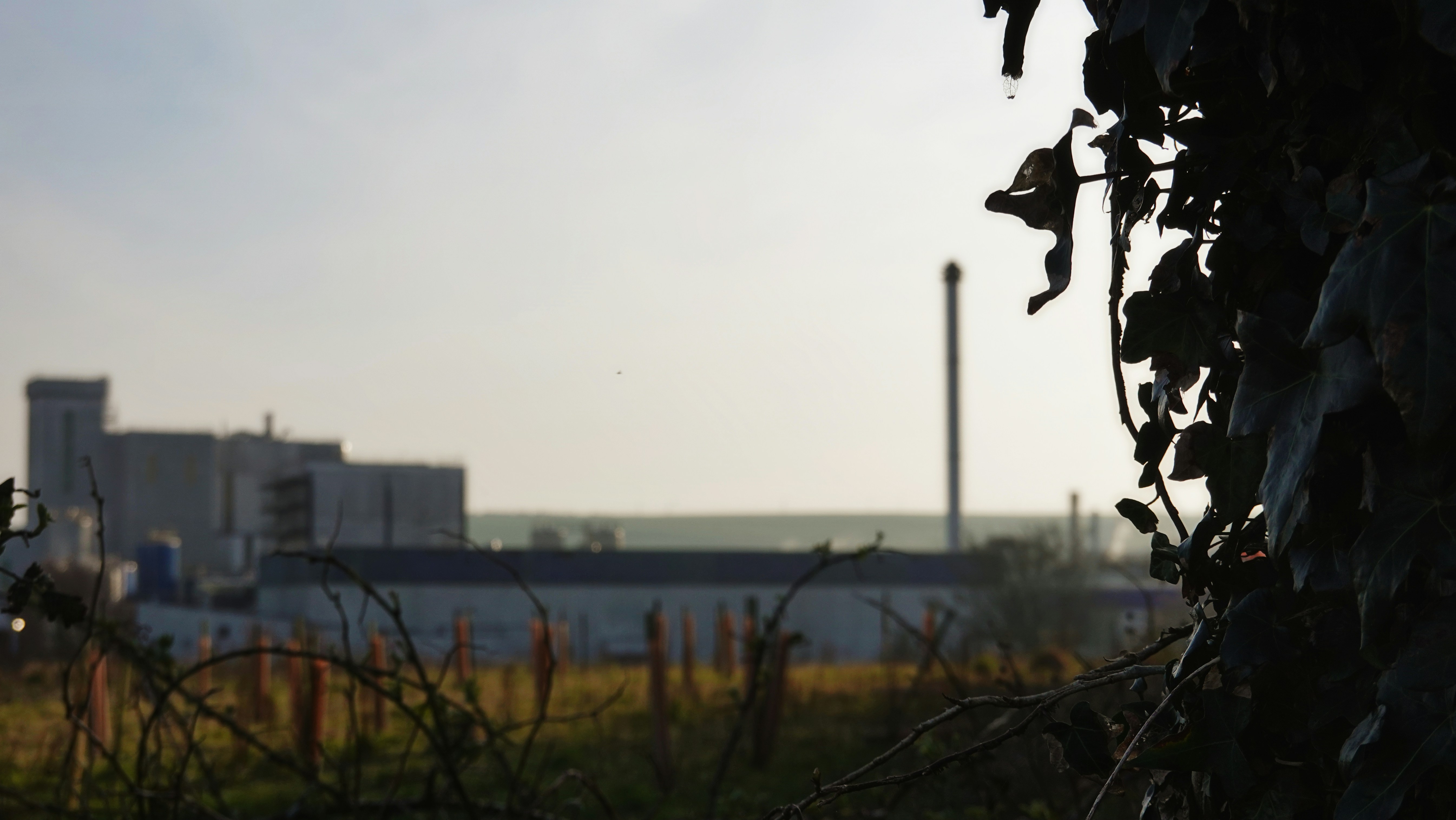 Industriegebäude mit einem Schornstein in der Ferne.